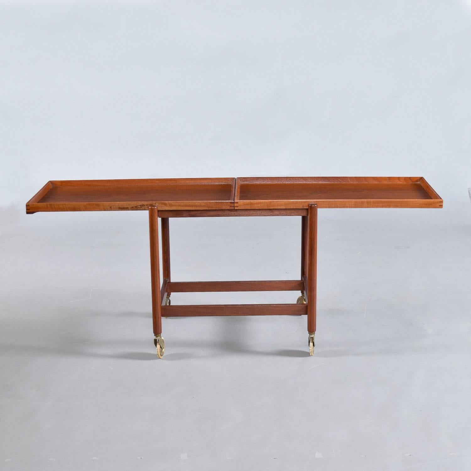 Dynamic, versatile, “the life of the party,” we’re not talking about you. Or are we? This Poul Hundevad Danish teak serving cart is more than meets the eye. Compact and unassuming until the party starts. Slide the top tray and position the bottom
