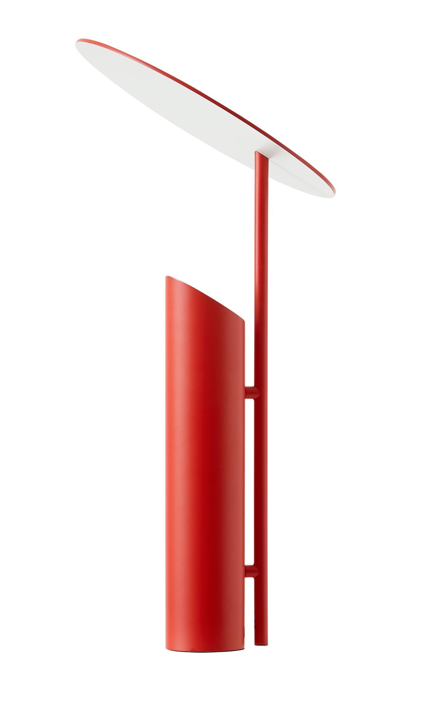 Table lamp with slanted disc shade which reflects the light coming from the base of the lamp (Light source facing upwards).

Material: 
All parts manufactured in steel 
Powder coated red
The down facing surface of disc shade powder coated white