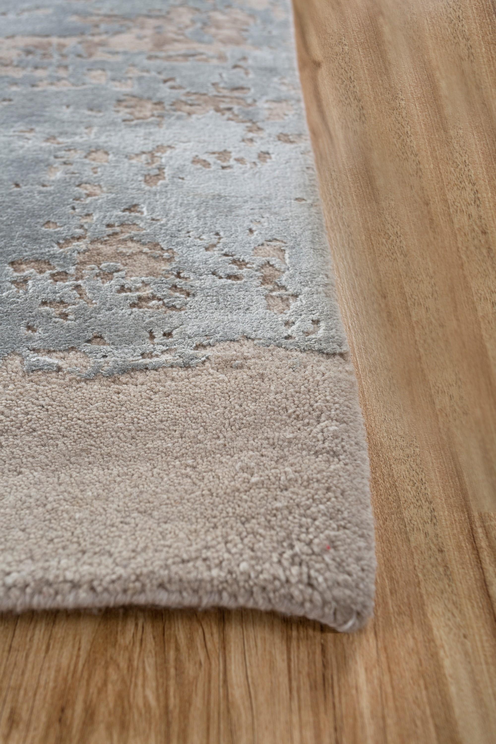 Embark on a serene journey with this hand-knotted rug capturing the essence of the vast sky. Its Caribbean sky ground and antique white border paint a tranquil canvas that invites a moment of pause and reflection. Designed for modern spaces, this