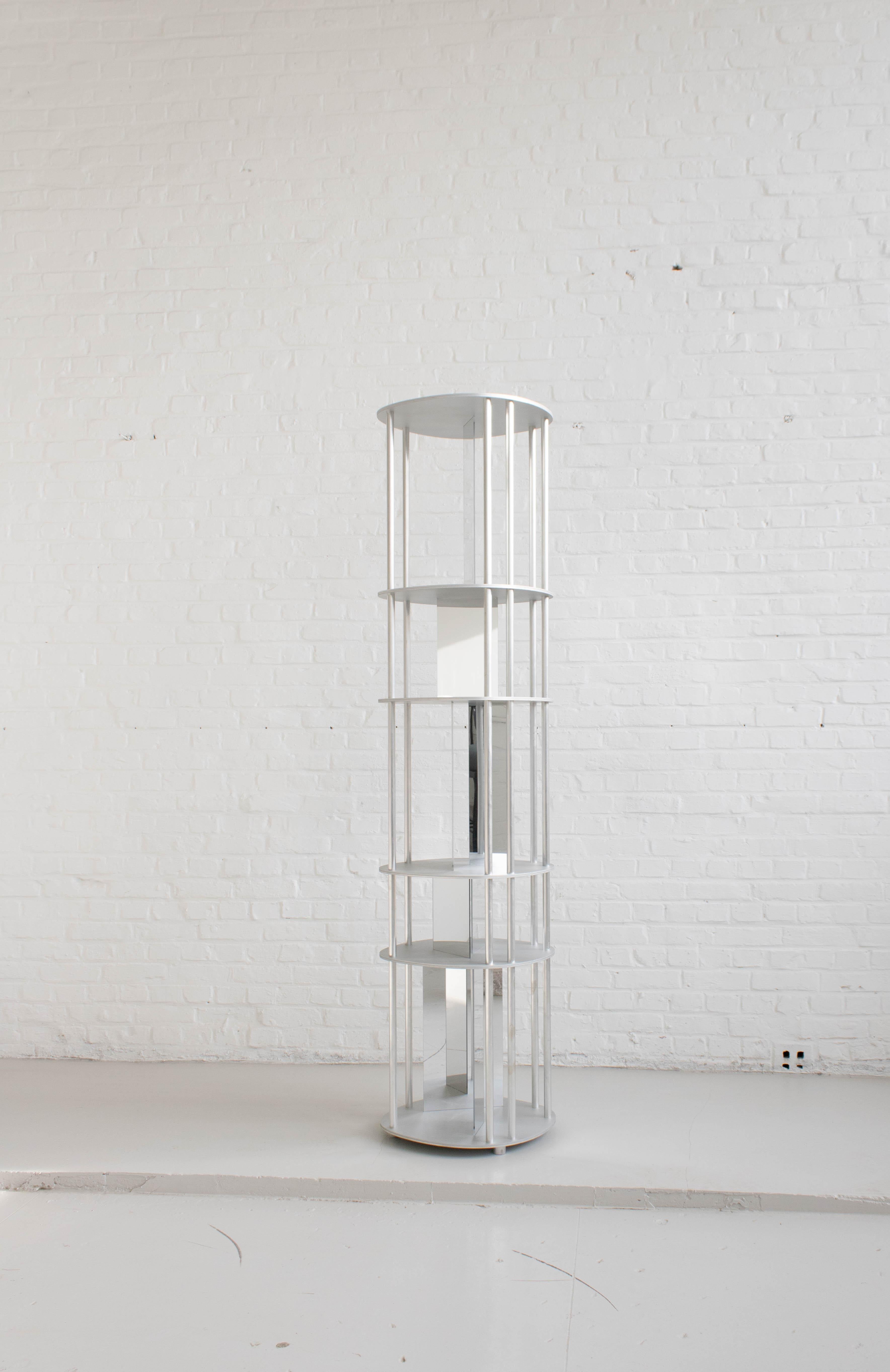 Reflektor rack by Arne Desmet
Dimensions: D 40 x W 43 x H 172.4 cm
Materials: Brushed aluminium plates, aluminium tubes, stainless steel.

Irregular shapes and element placement form the base of the Reflektor rack. The shelves of the object are