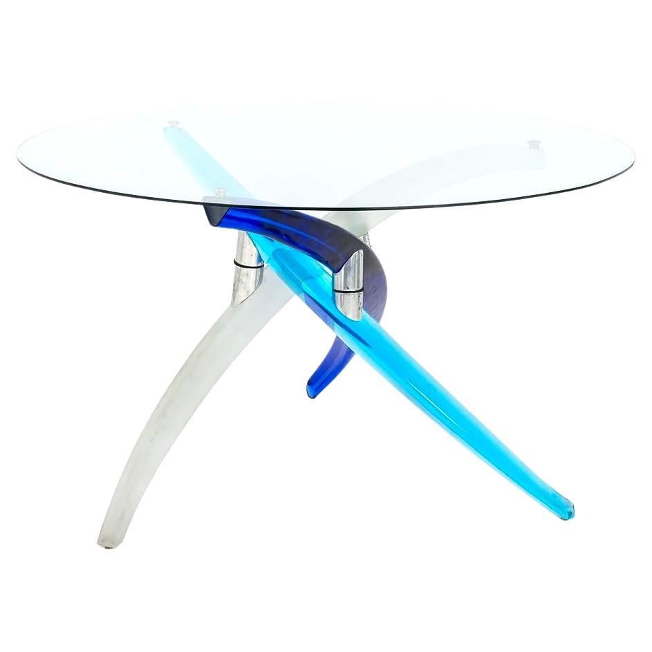 La table Fili D' Artistics de Reflex est une symphonie visuelle de formes inoubliables et d'ingénierie structurelle artistique. La base est composée de trois pieds solides en verre de Murano dont les courbes gracieuses s'élancent vers le haut et