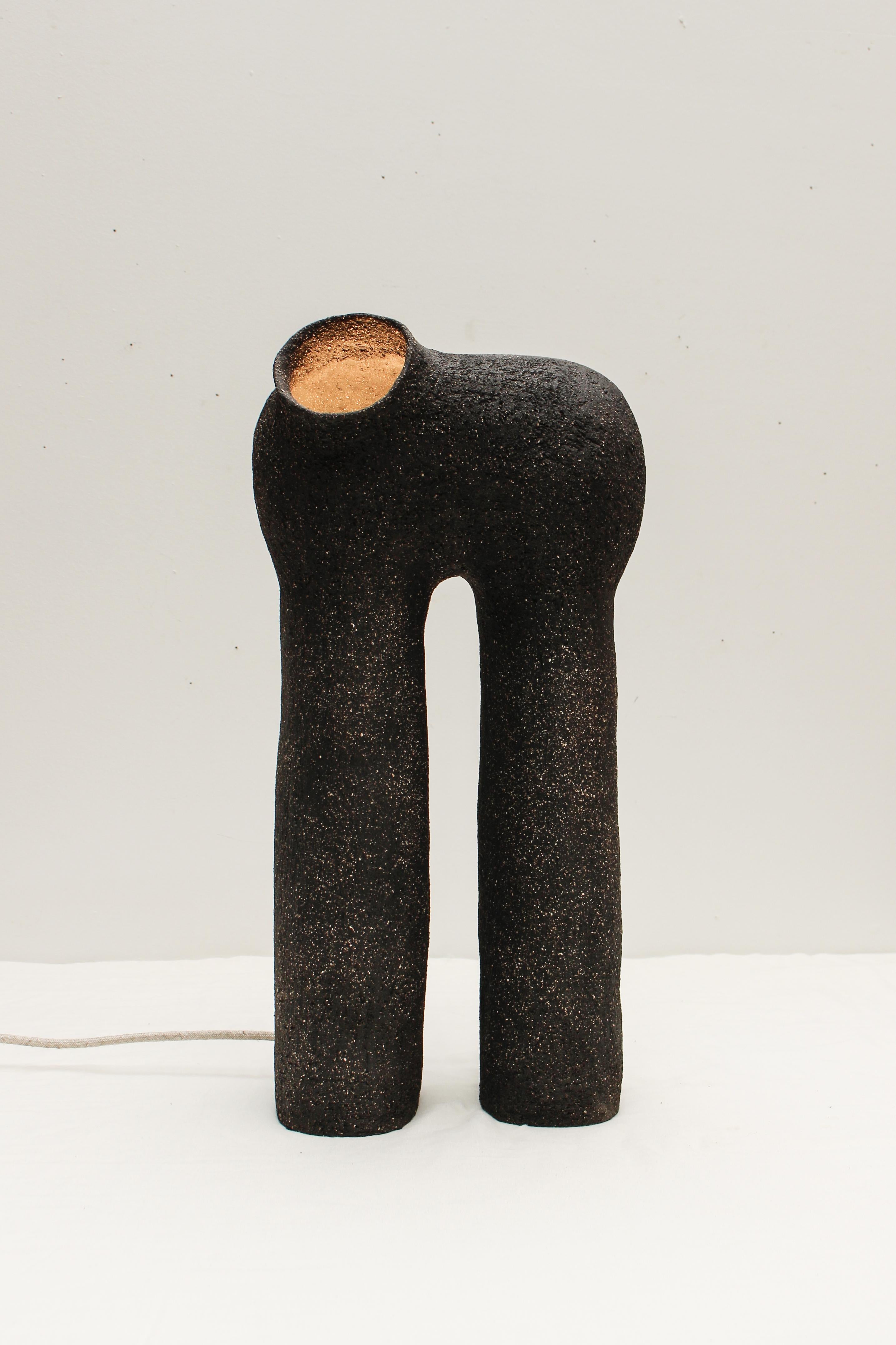 Refuge black stoneware table lamp by Elisa Uberti
Materials: Black stoneware
Dimensions: Around 55/60cm

After fifteen years in fashion, Elisa Uberti decides to take the time to work with these hands and to give birth to new