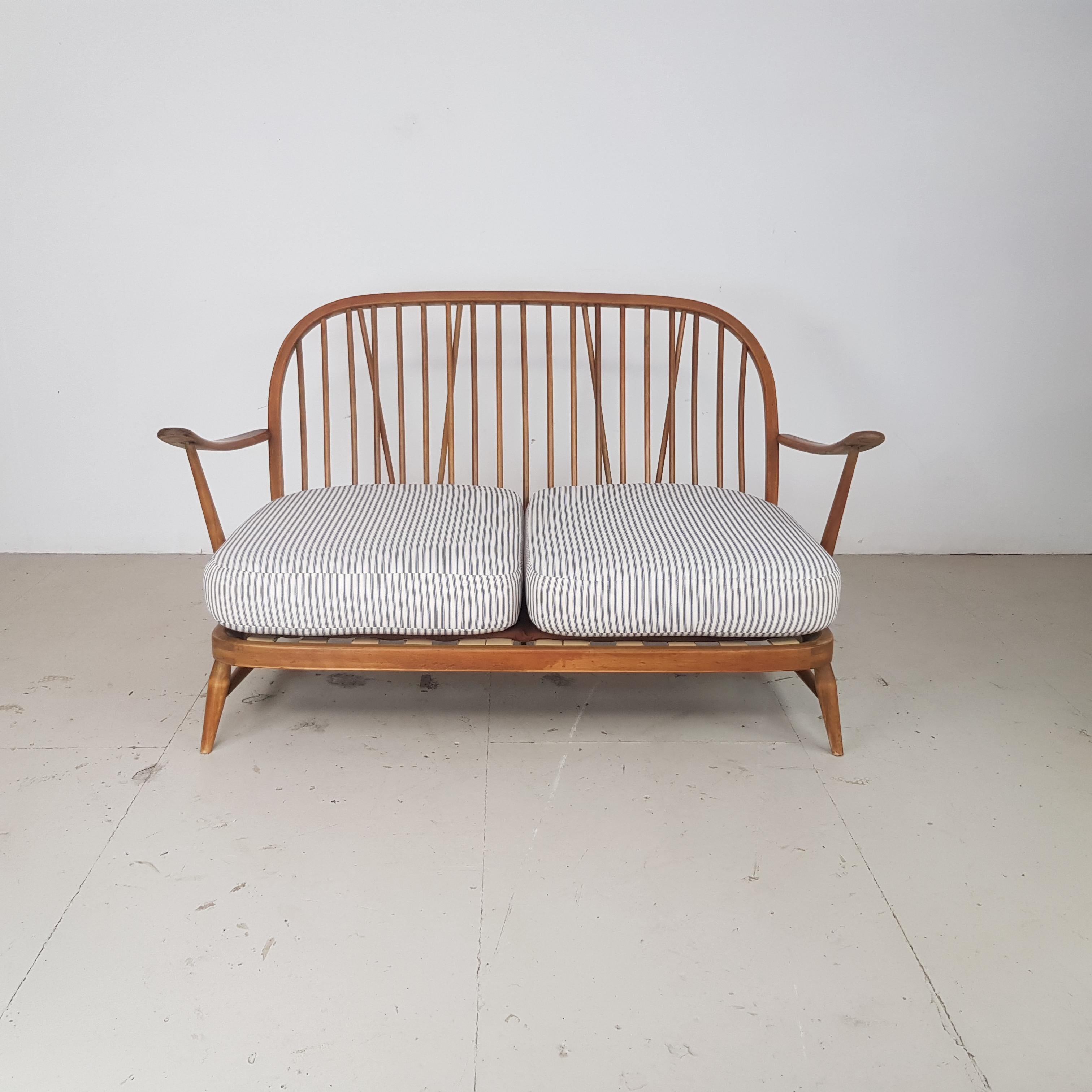 Refurbished blonde Ercol Windsor 2-seat sofa.

Newly upholstered in lovely French ticking. 

This piece is in good vintage condition.  The frame is solid and sturdy.  There are a few scuffs, scratches and marks commensurate with age but nothing