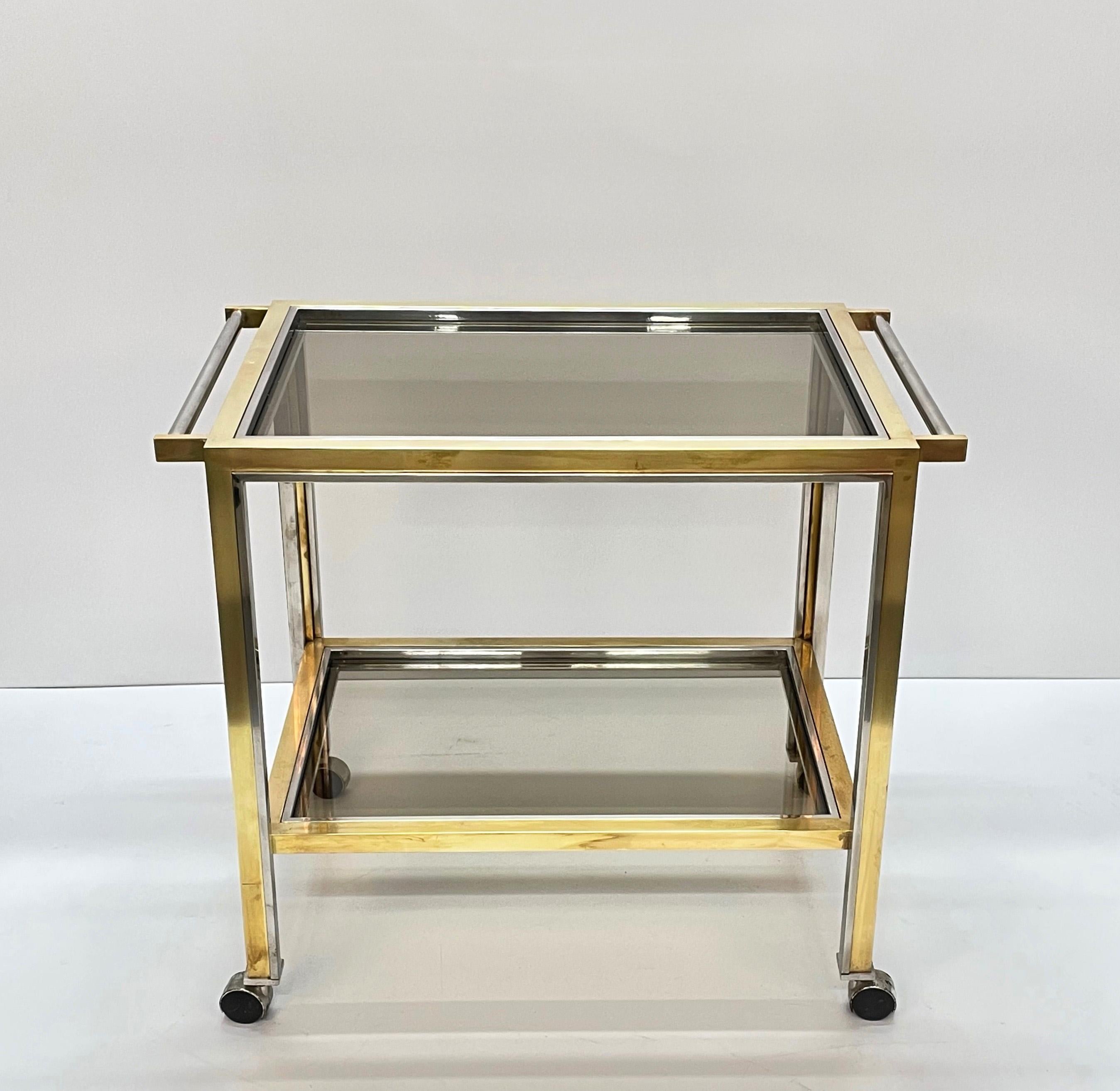 Beautiful bar trolley with Hollywood Regency design. This fantastic coffee table was made in Italy in the 1970s and is attributed to Romeo Rega.

This trolley with chromed steel handles has two smoked glass shelves. This fantastic piece features a