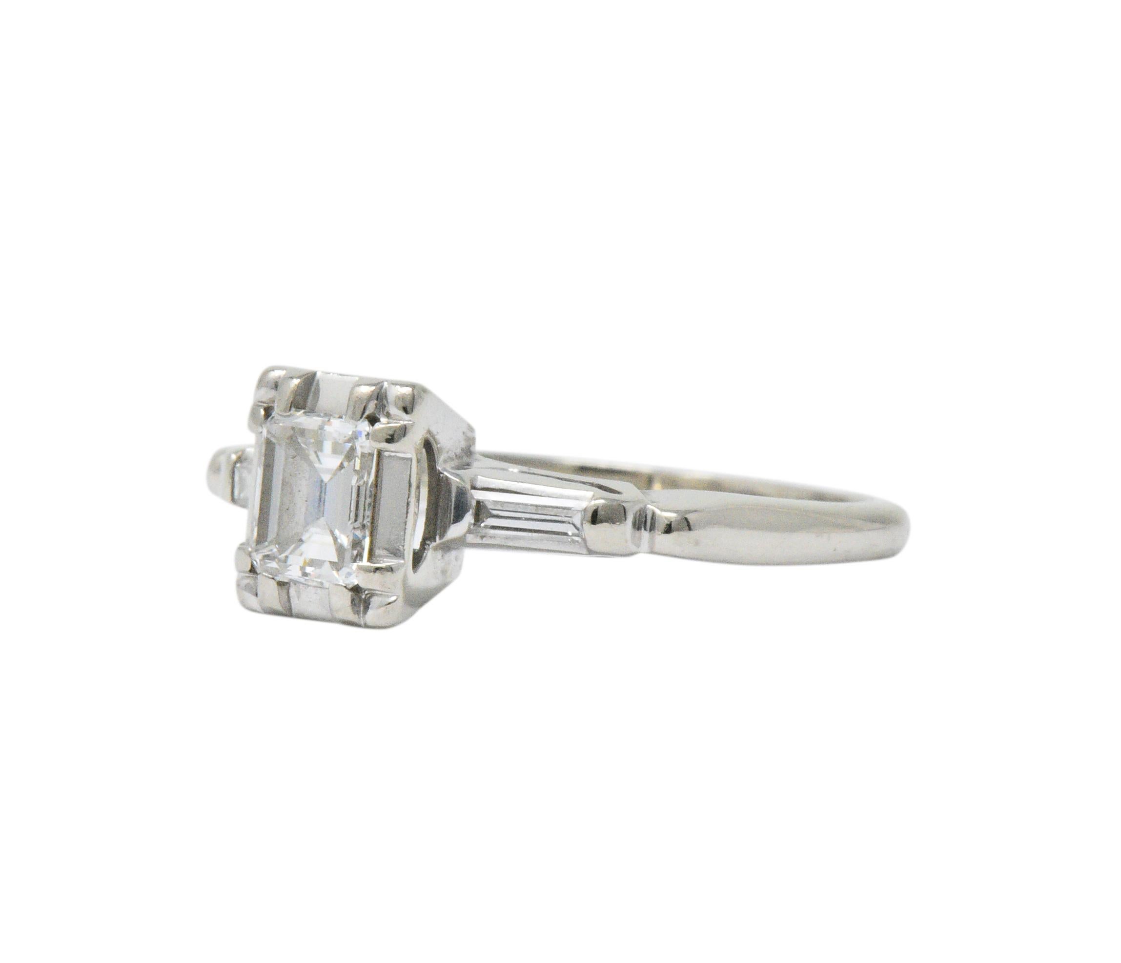 Centering an emerald cut diamond weighing approximately 0.40 carat, G color and VVS clarity

Flanked by straight baguette cut diamonds on both sides, weighing approximately 0.05 carat total, G/H color and VS to SI clarity

The center diamond is in a