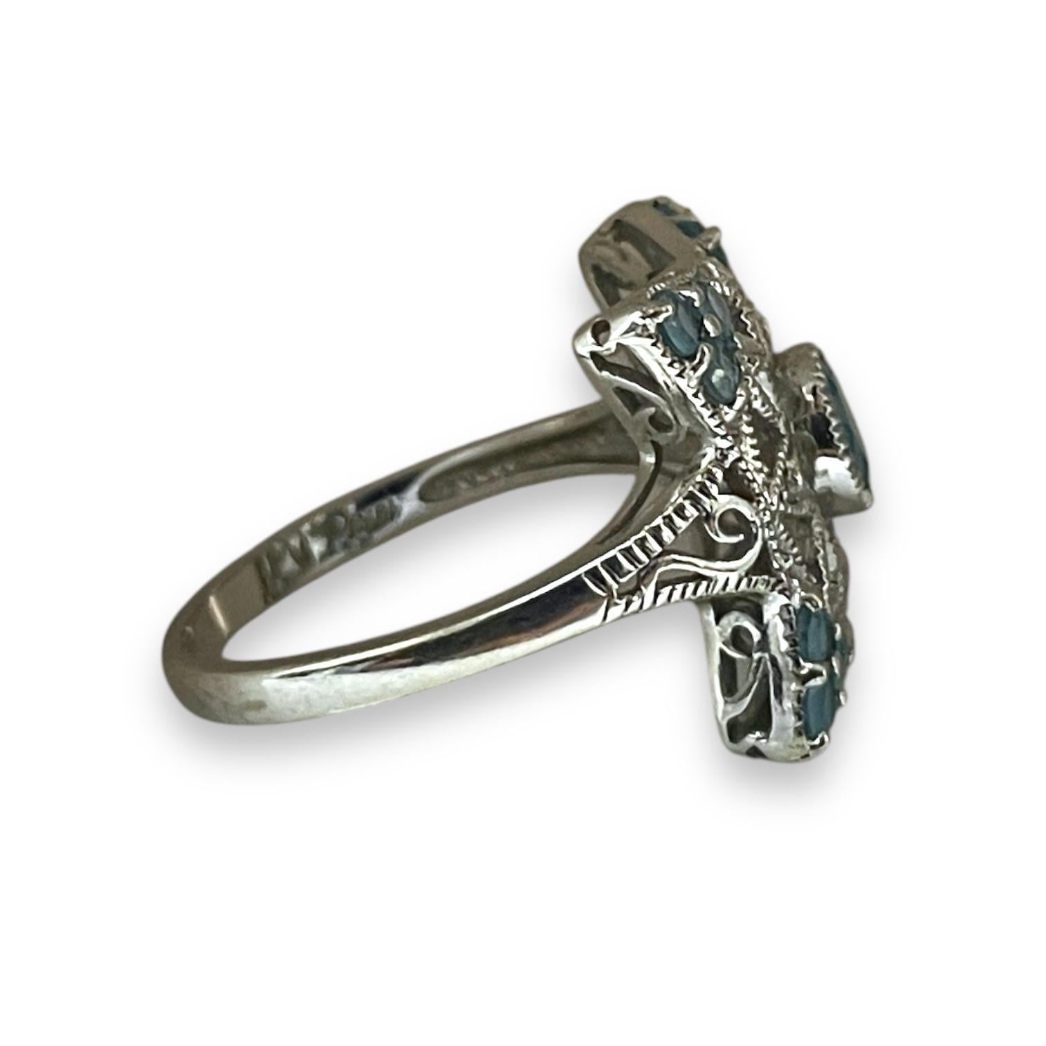 Questo splendido anello in oro bianco è caratterizzato da un'incantevole pietra color acqua al centro, circondata da intricati disegni floreali. La lavorazione dettagliata conferisce all'anello un'aria elegante, con le pietre color acqua incastonate