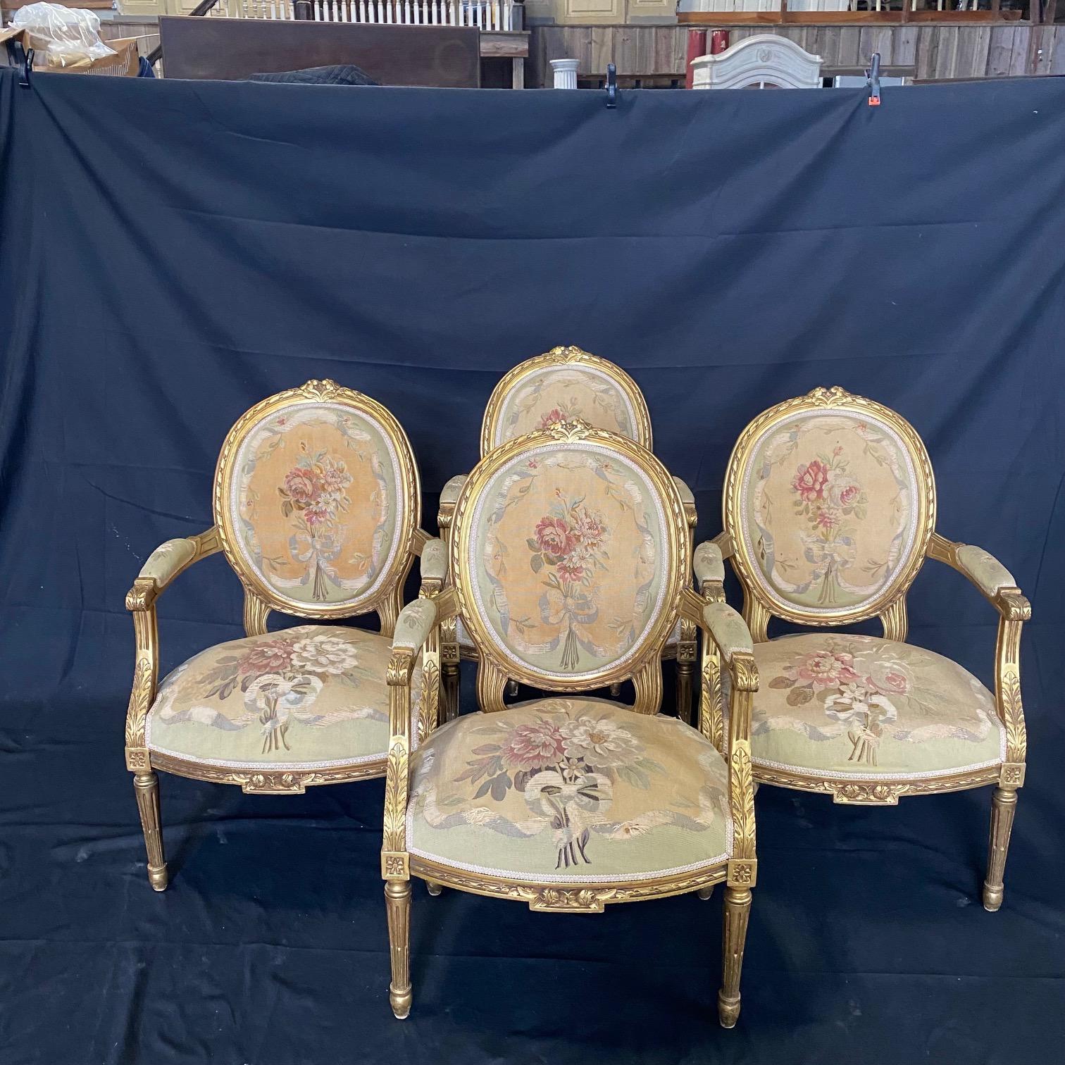 A magnificent 19th century French Louis XVI five piece carved walnut parlor suite richly upholstered in exceptional and rare handwoven Aubusson tapestries. The set includes four armchairs and a sofa or canapé, each finely carved with giltwood