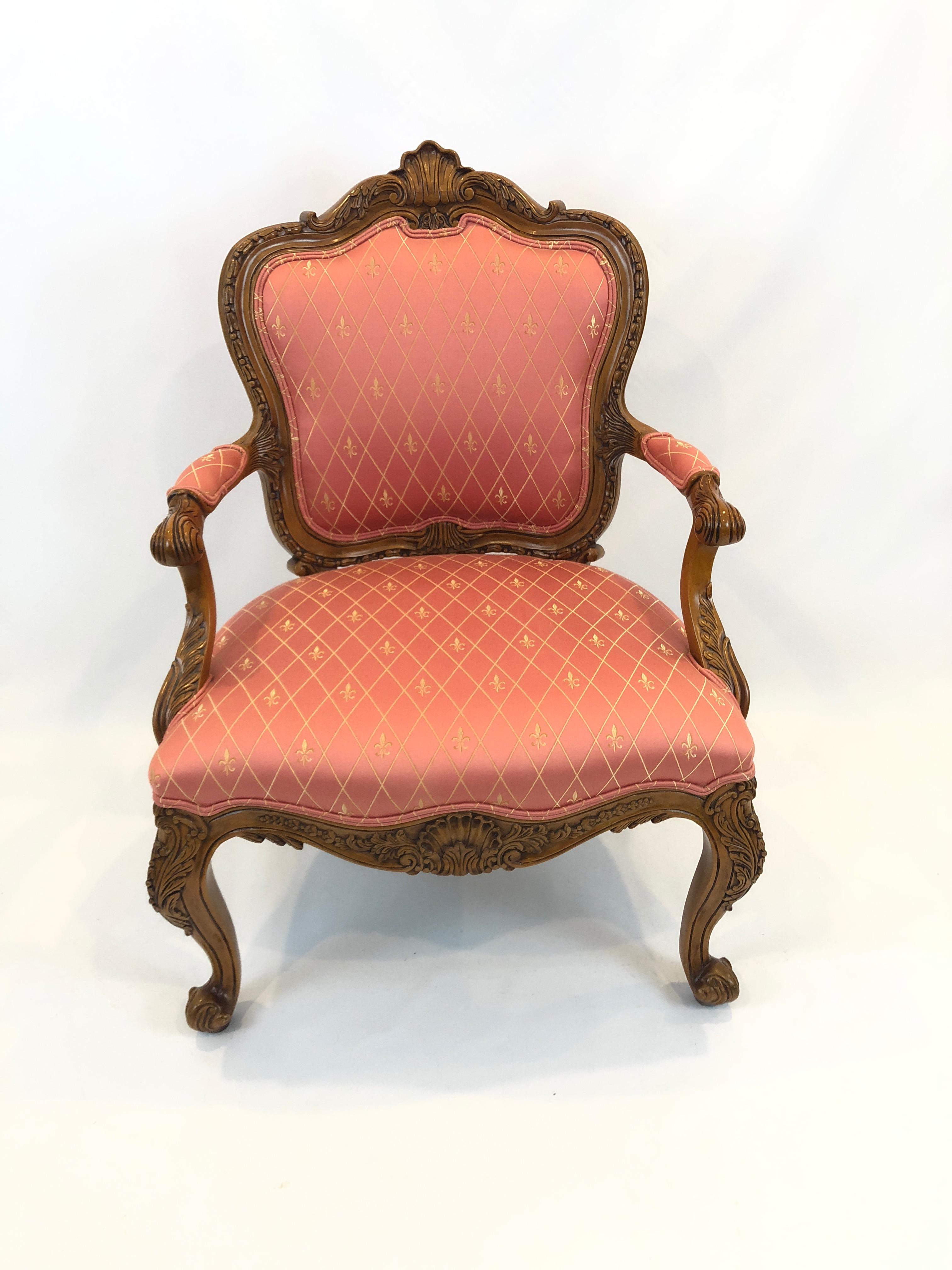 Very fancy ornately carved fruitwood armchair upholstered in rasberry fabric with fleur di lis pattern.
Arm height 25
seat depth 19.