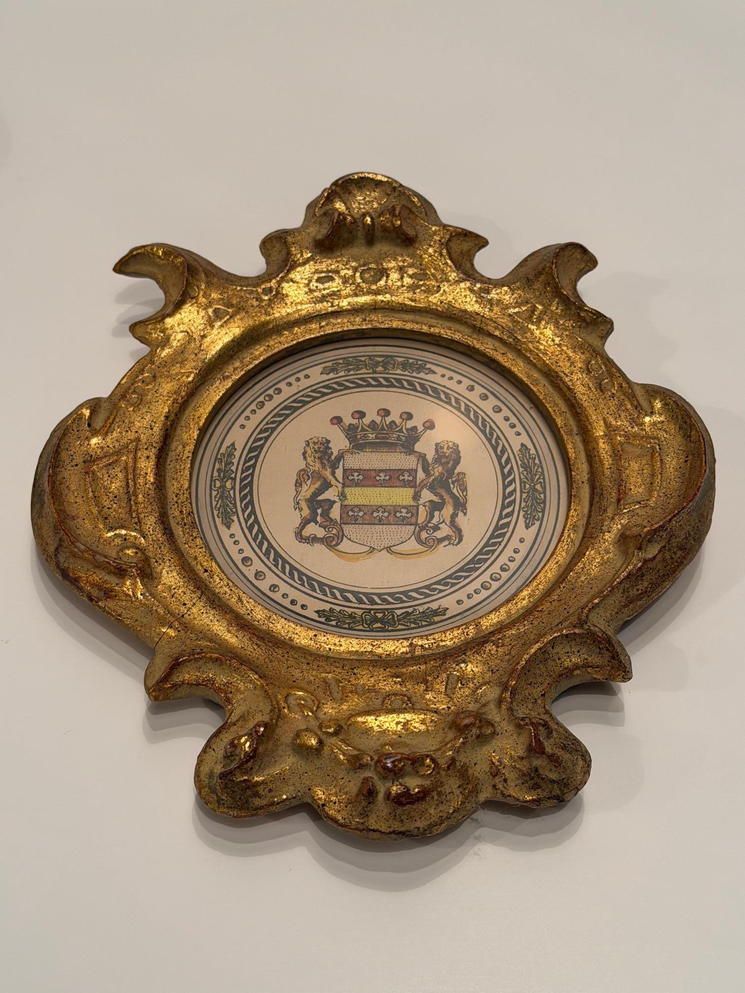 Élégante paire de petites plaques en plâtre doré avec des empreintes de lion à l'intérieur.