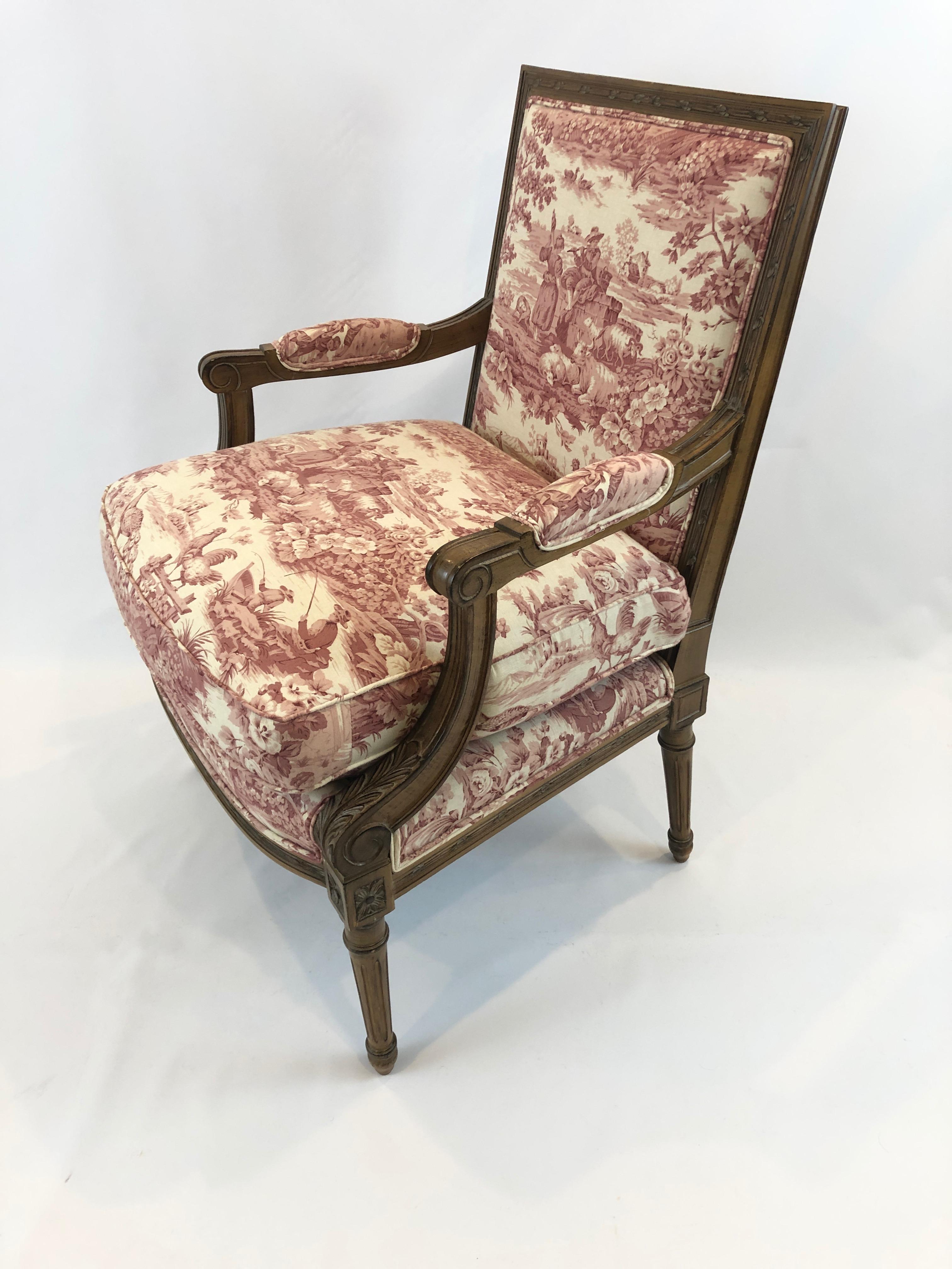 Stately comfortable carved and antiqued fruitwood armchair in the French style having lovely rasberry and cream toile upholstery. Attributed to Girard Emelia.
Measures: Arm height 25 inches, seat depth 21.5.