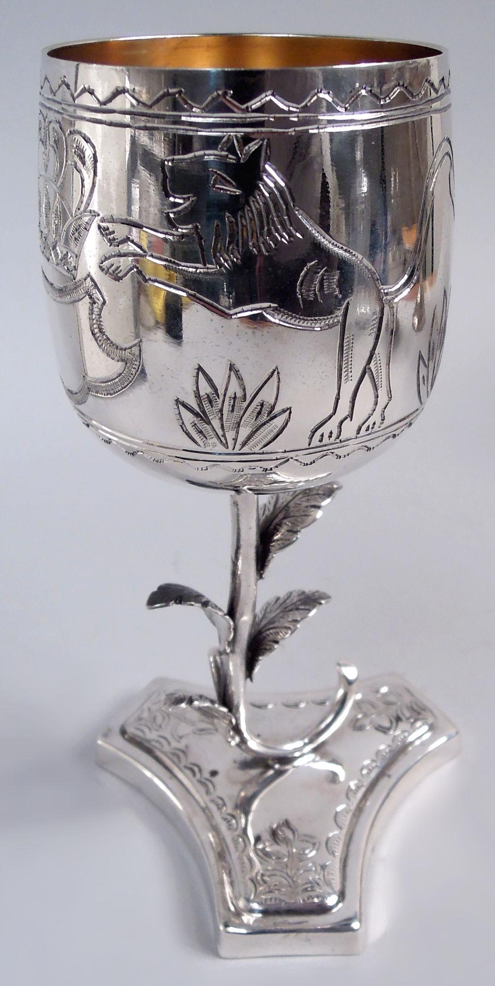 Regal sterling silver goblet, ca 1960. Curved and upward tapering bowl with chased armorial surmounted by crown and flanked by deer and lion; lined and wavy borders. Leafing stem mounted to truncated and concave tripartite foot with flowers and