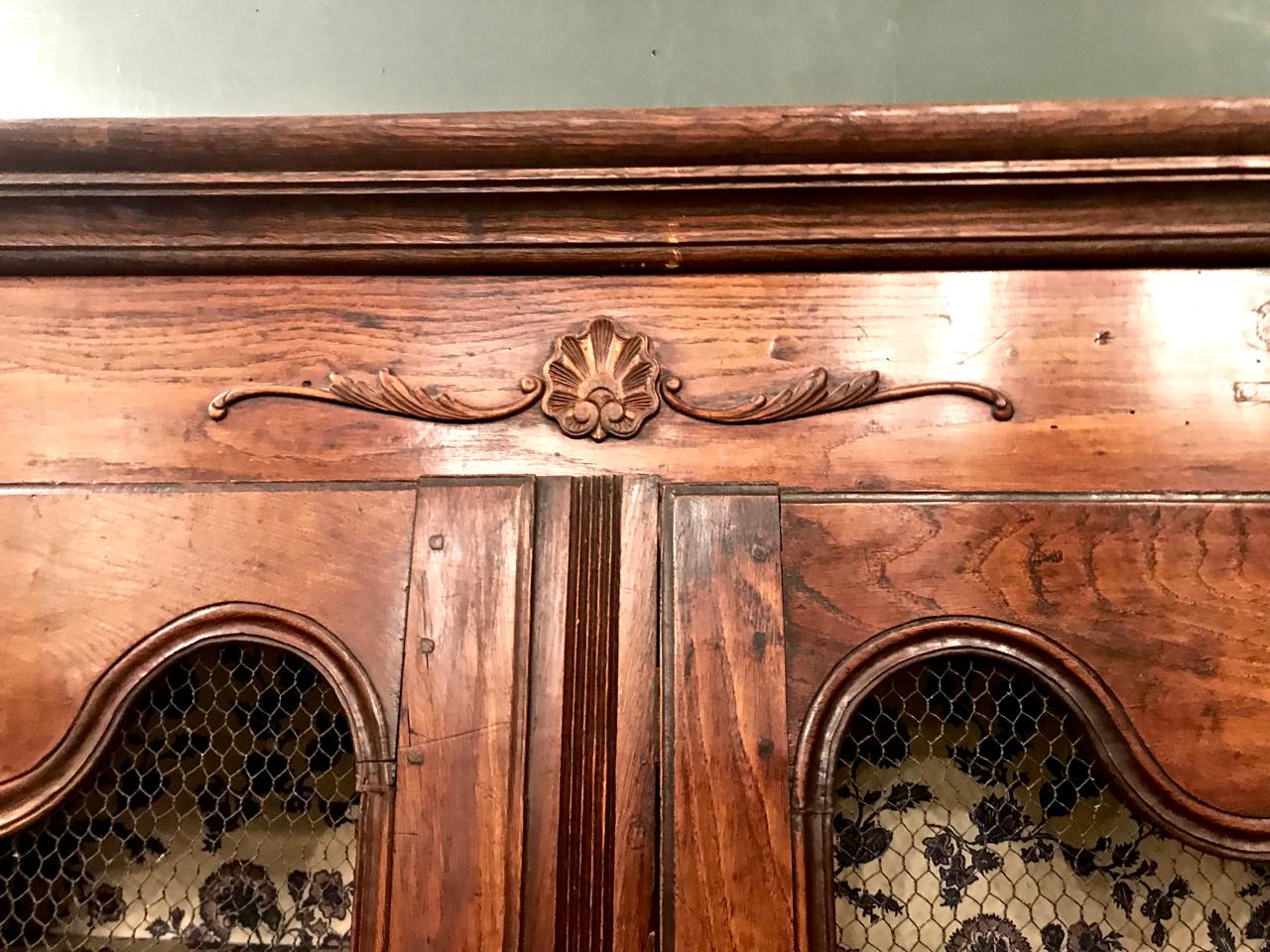 This is an uncommon size of provincial period Regence Bibliotheque or bookcase. The simply, but finely, carved shell motif, form of foot and oak construction are indicative a period French Regence piece. The 15