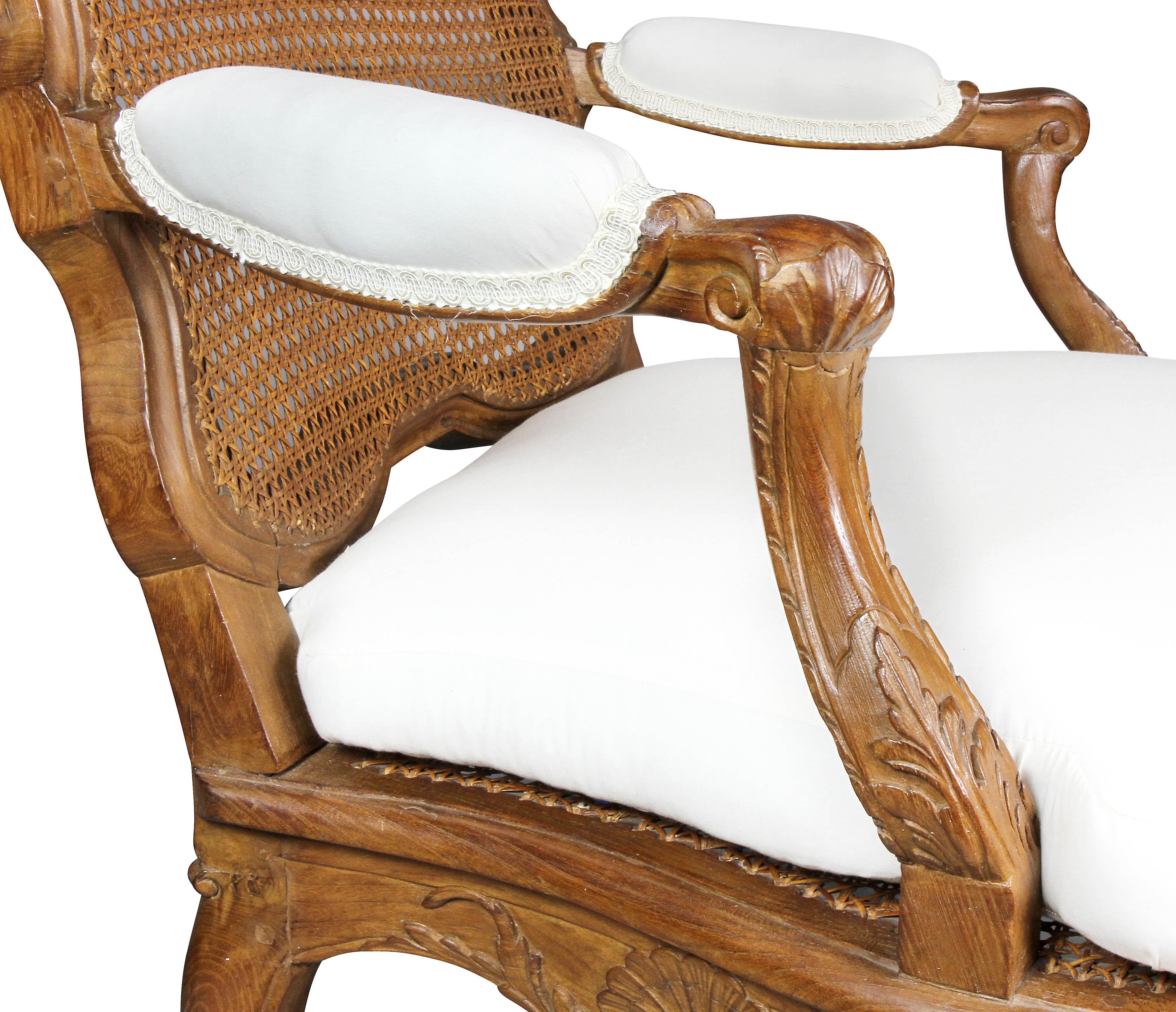 Arched shell carved crest rail surrounding a caned back, serpentine caned seat with loose cushion raised on cabriole legs and shaped-X form stretchers. Provenance; Gene Tyson Antiques, William Hodgins Design.