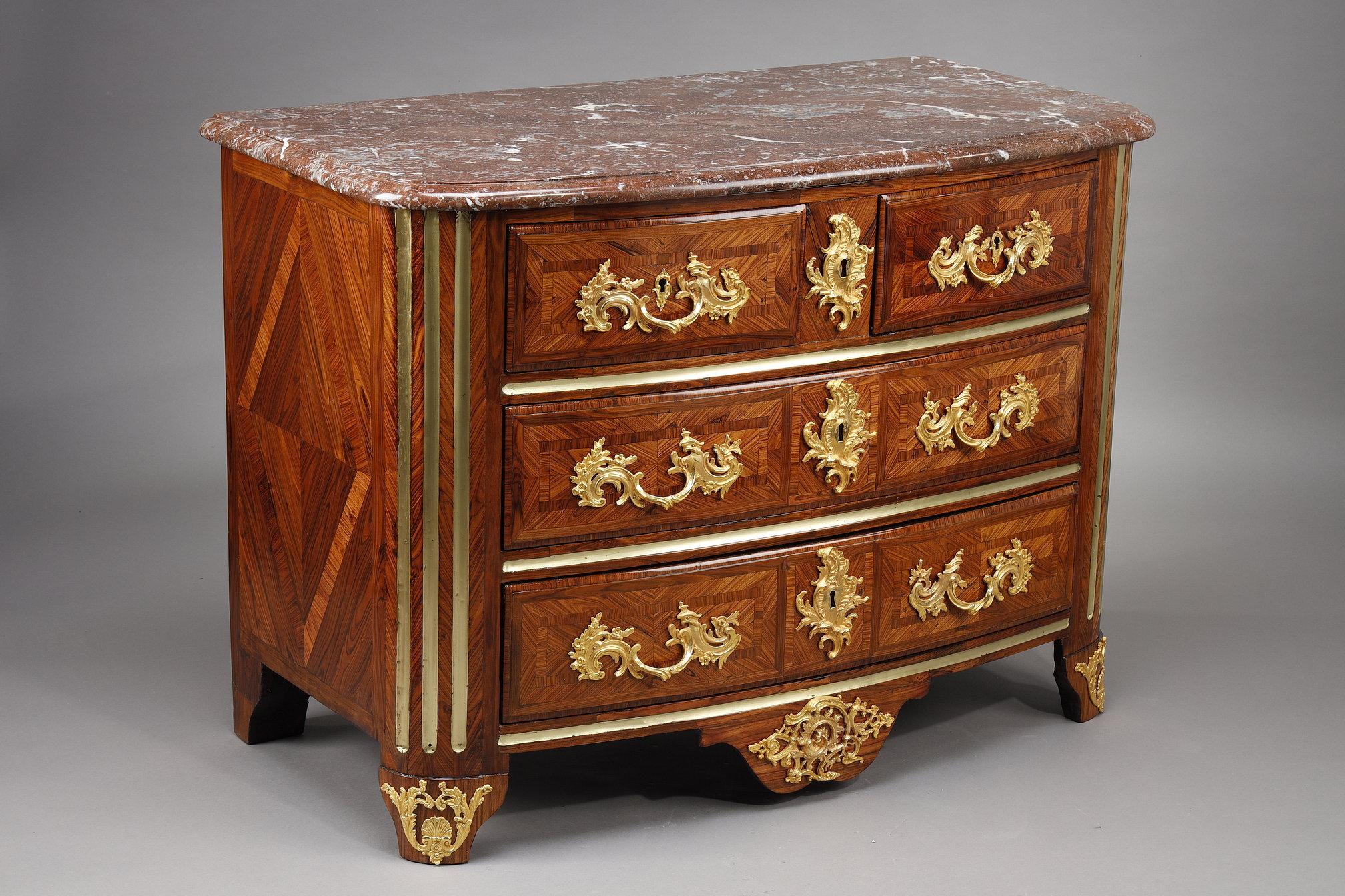 Chest of drawers in violet wood, the curved front opening to five drawers in three rows, the top in red marble from Flanders resting on rounded fluted uprights, beautiful ormolu ornamentation.

The PM iron remains a mystery for the time being: we