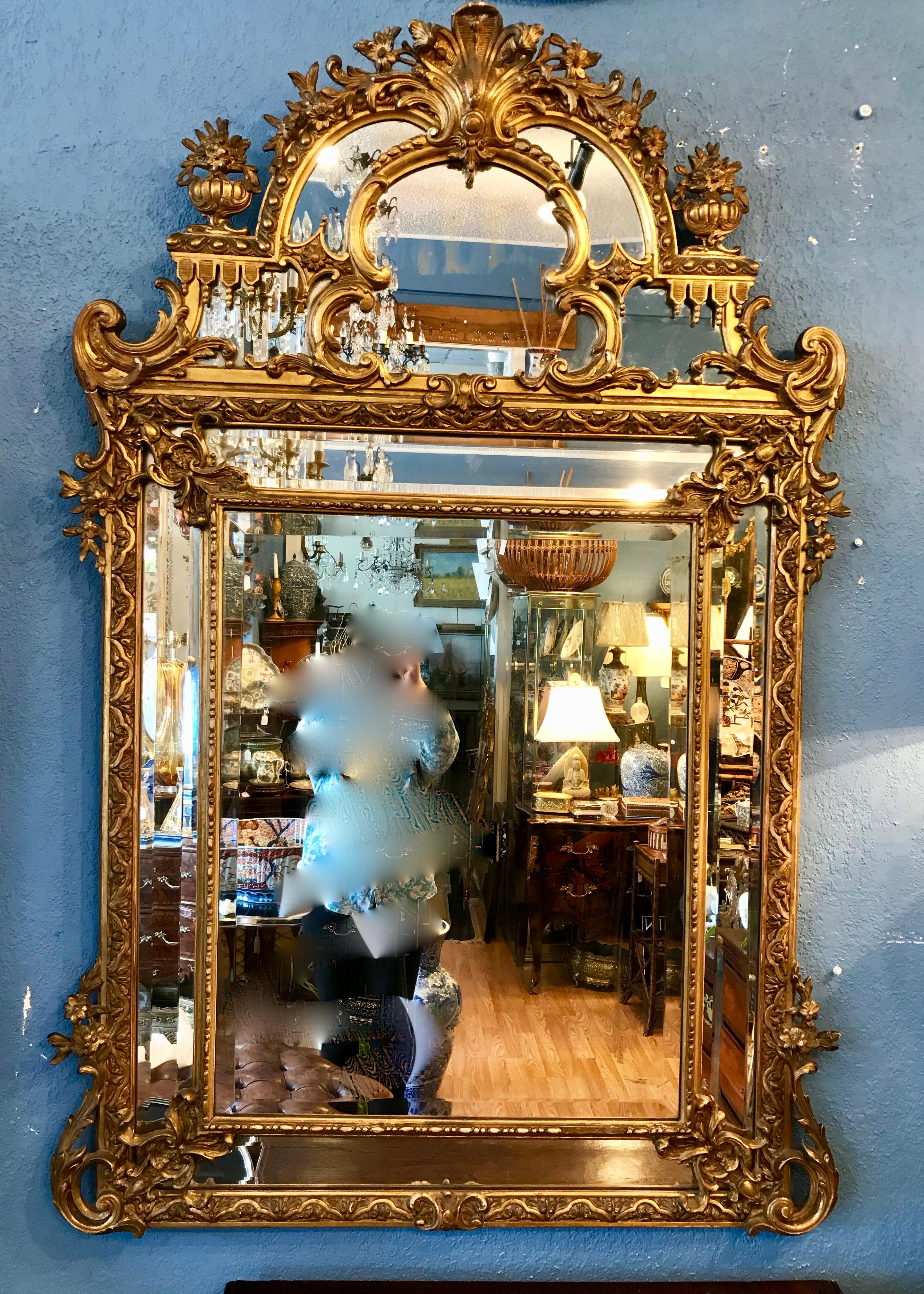 Dramatic scale and proportions . The mirror is exquisitely carved and detailed.
Fine 19th century workmanship. Each of the 4 bottom half mirrored panels are beveled.
The top is appointed with finials and a central shell carved cartouche.