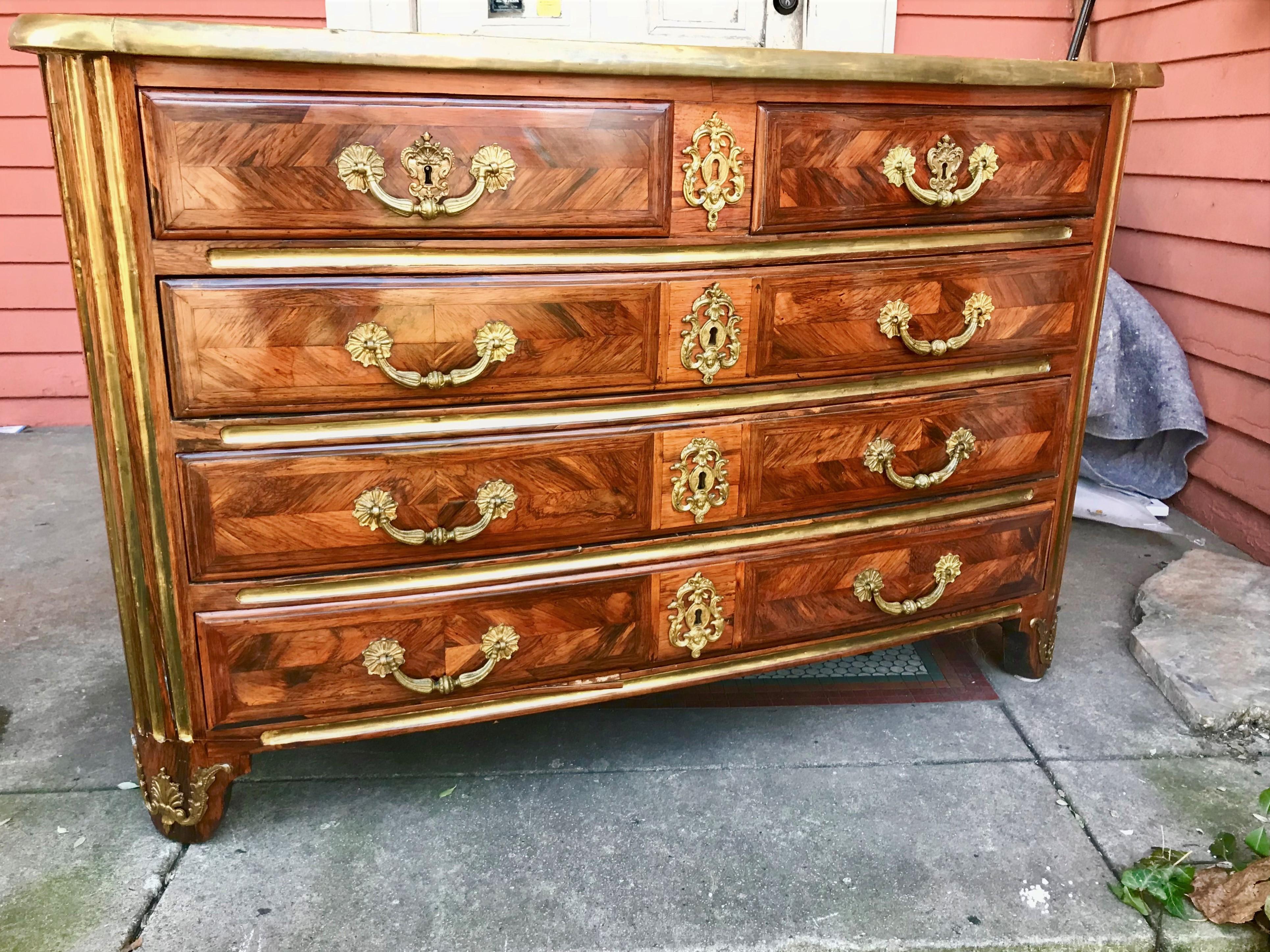 Period kingwood Regence commode early 18th century  with gilt bronze mounts and gilded stiles (at each corner and between drawers) .Stately with two short drawers over three long drawers. The top with blooming inlaid pineapples in each corner and