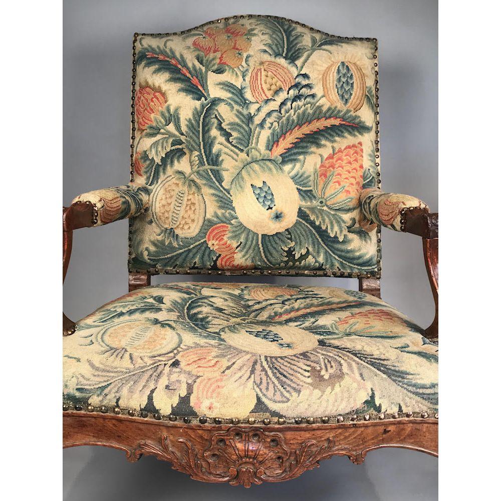 This large scale antique walnut armchair has very generous proportions, is well carved, and is of a well patinated rich colour.
Apparently retaining the original close-nailed tapestry cover, which still exhibits vibrant colours.

Early 18th