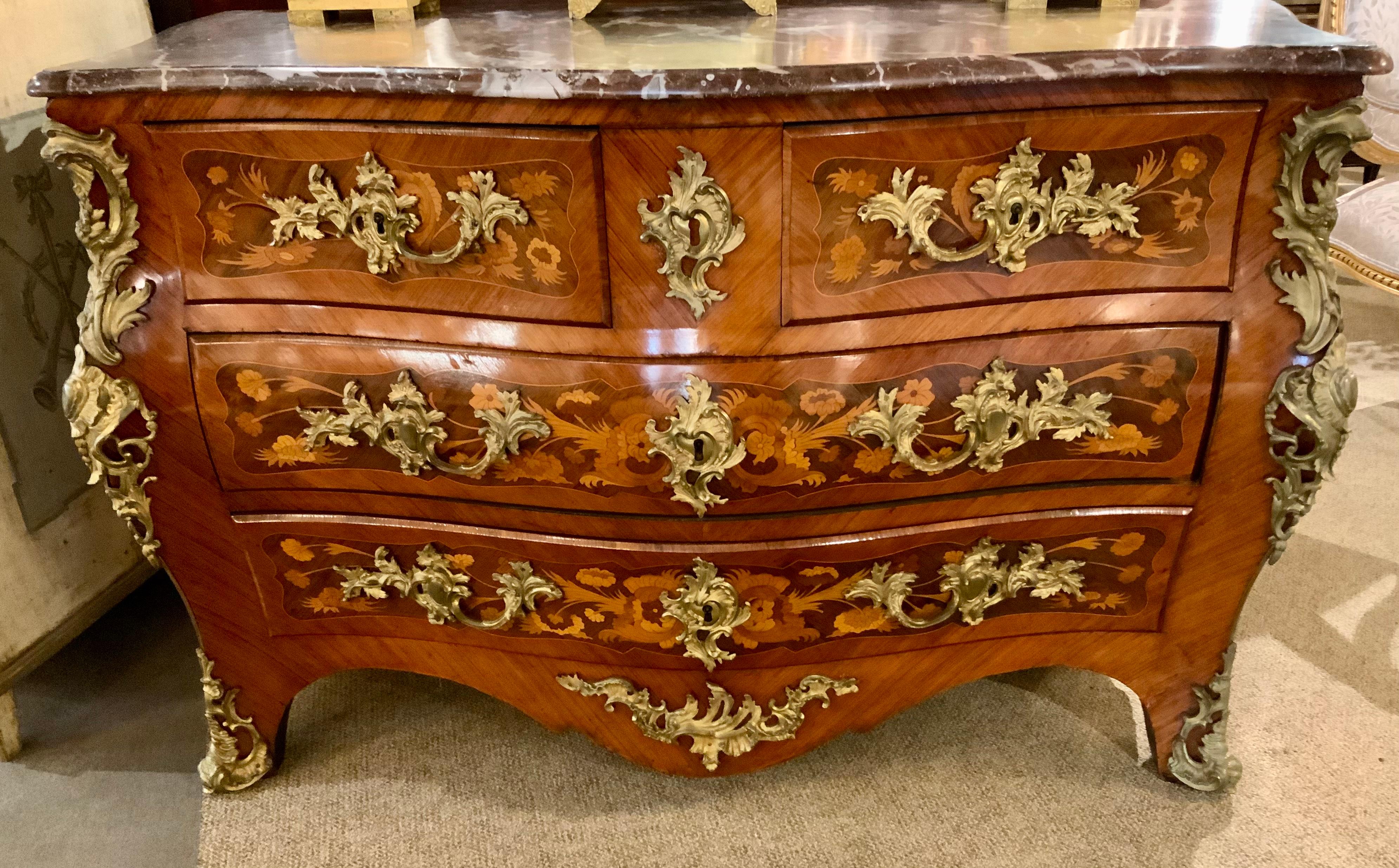 This special Regence-Style commode is early 19th century,
It is a rare and elegant piece because of the fine marquetry 
That is exhibited throughout this cabinet. The shape is in a
Bombe’ form and the front has a serpentine shaped marble.
The