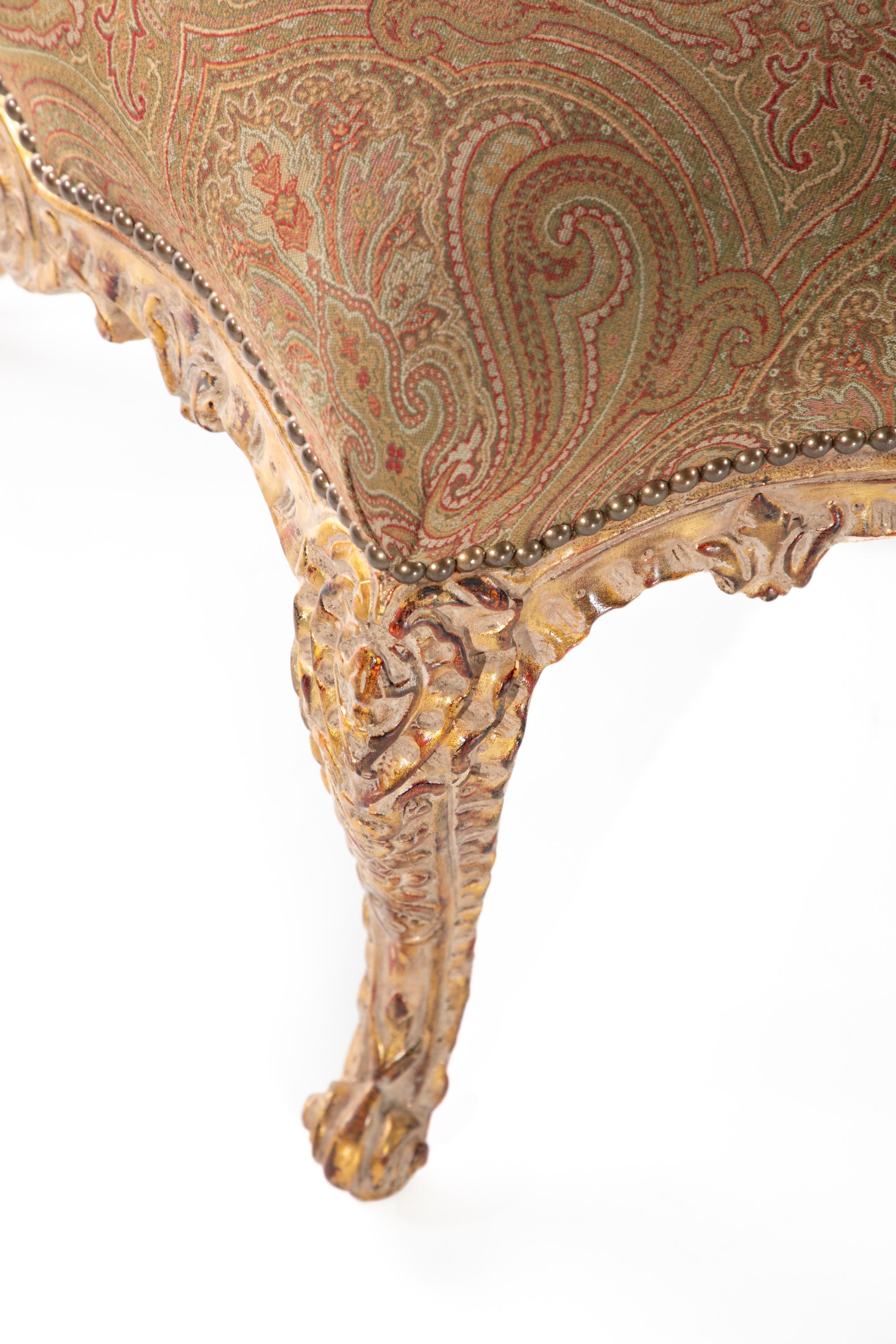 Pouf imbottito in legno dorato e intagliato.  
