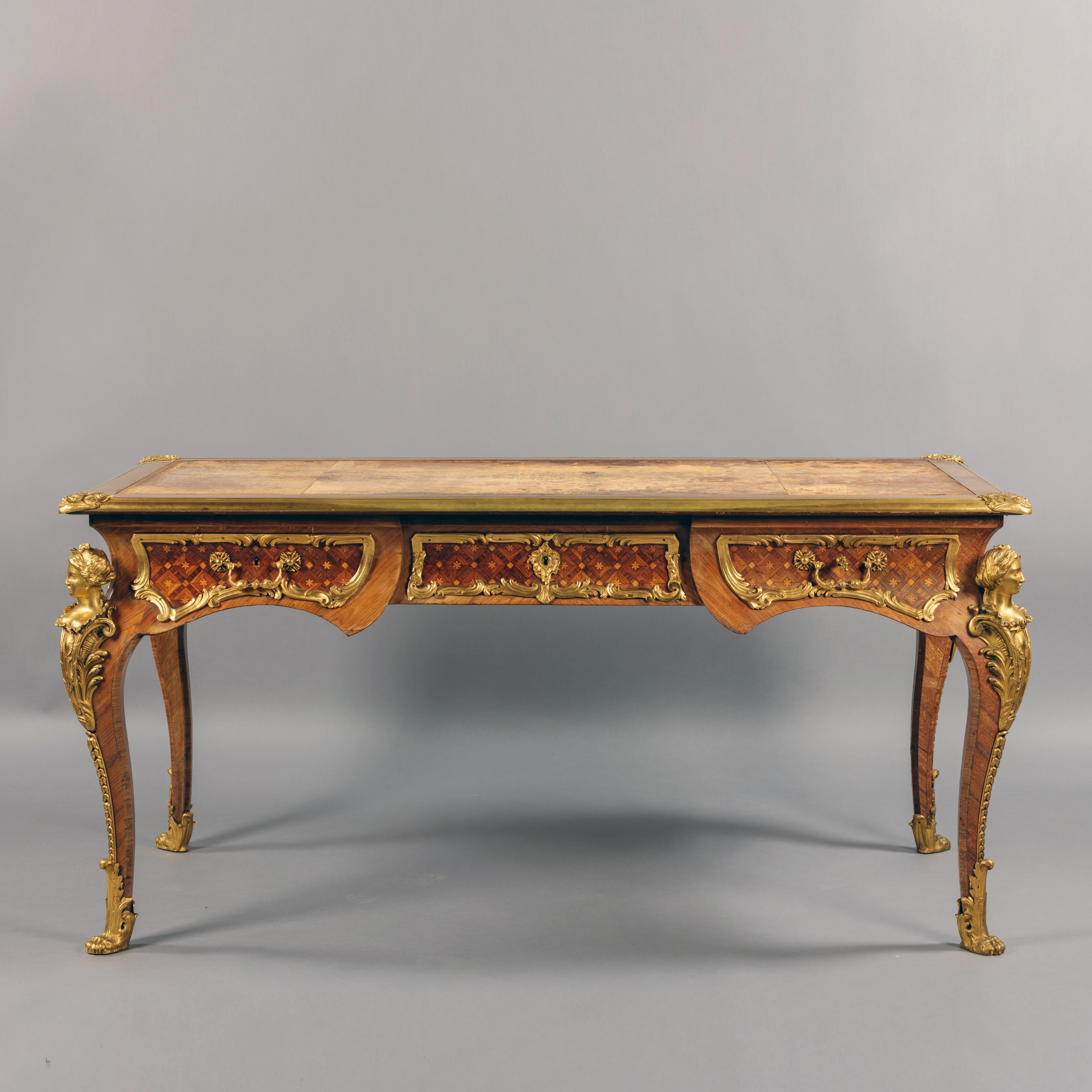 A fine Regence style gilt-bronze mounted parquetry bureau plat, in the manner of Charles Cressent.

This fine parquetry inlaid bureau plat has a tooled leather top and sumptuous gilt-bronze mounts.

The desk has a shaped frieze fitted with three