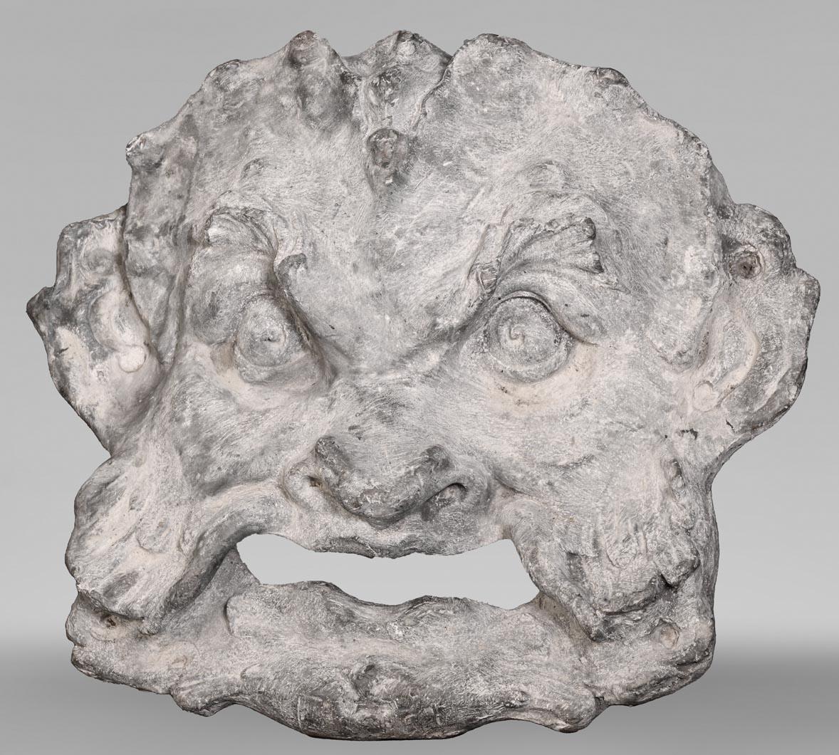 Francia, XIX secolo
Piombo

Questa maschera ornamentale per fontane esemplifica lo stile Regence, un'estetica di transizione tra il tardo barocco e il rococò francese. Fuso in piombo, il volto grottesco presenta tratti esagerati e motivi fantastici