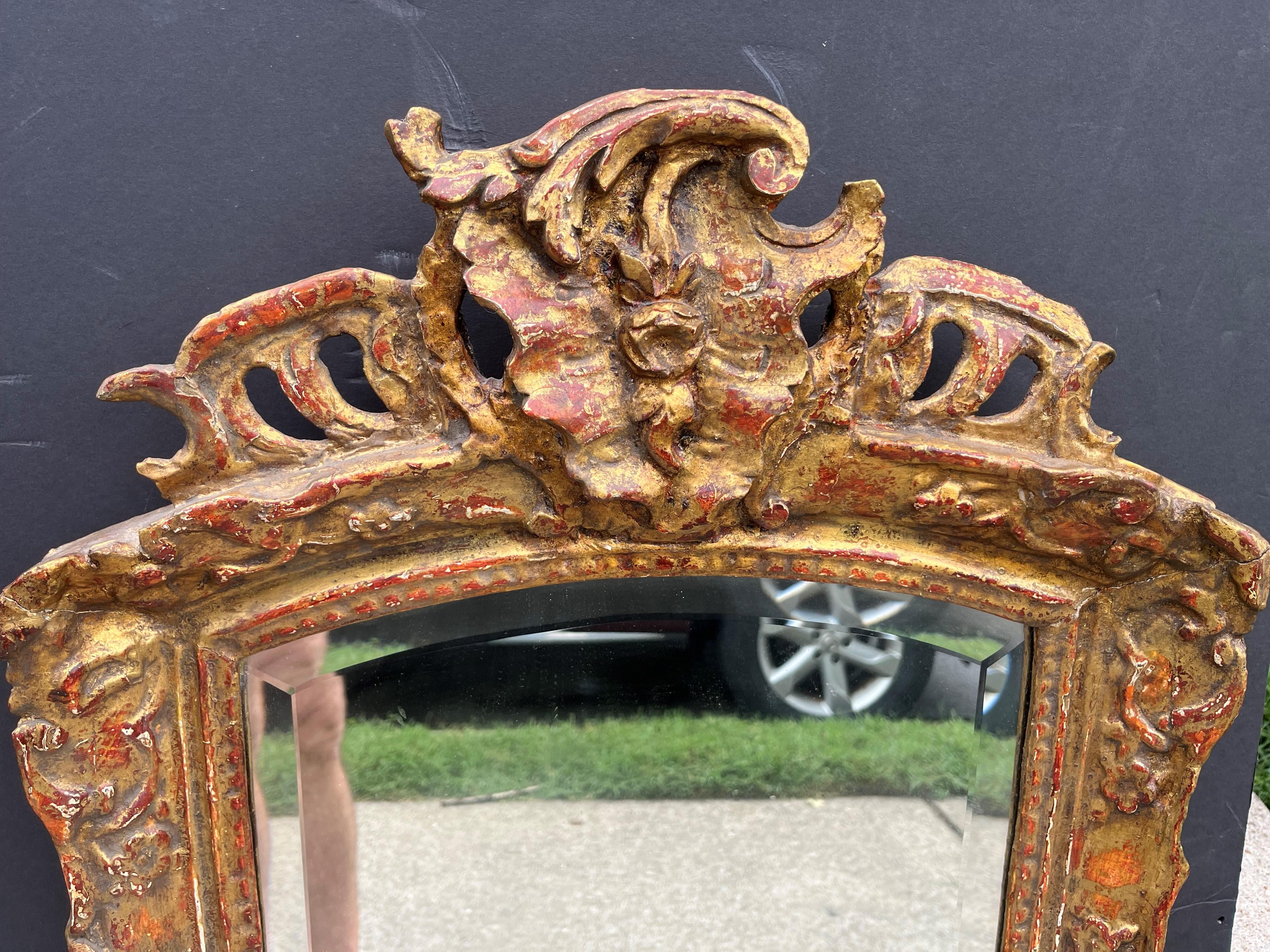  With later beveled plate .The whole with pierced crest, floral or foliate motifs and 'c' scrolls throughout. Touchups to gilt. Extensive bleeding of the bole in three charming colors, the usual Venetian red, a more Italian orange and a Chinese