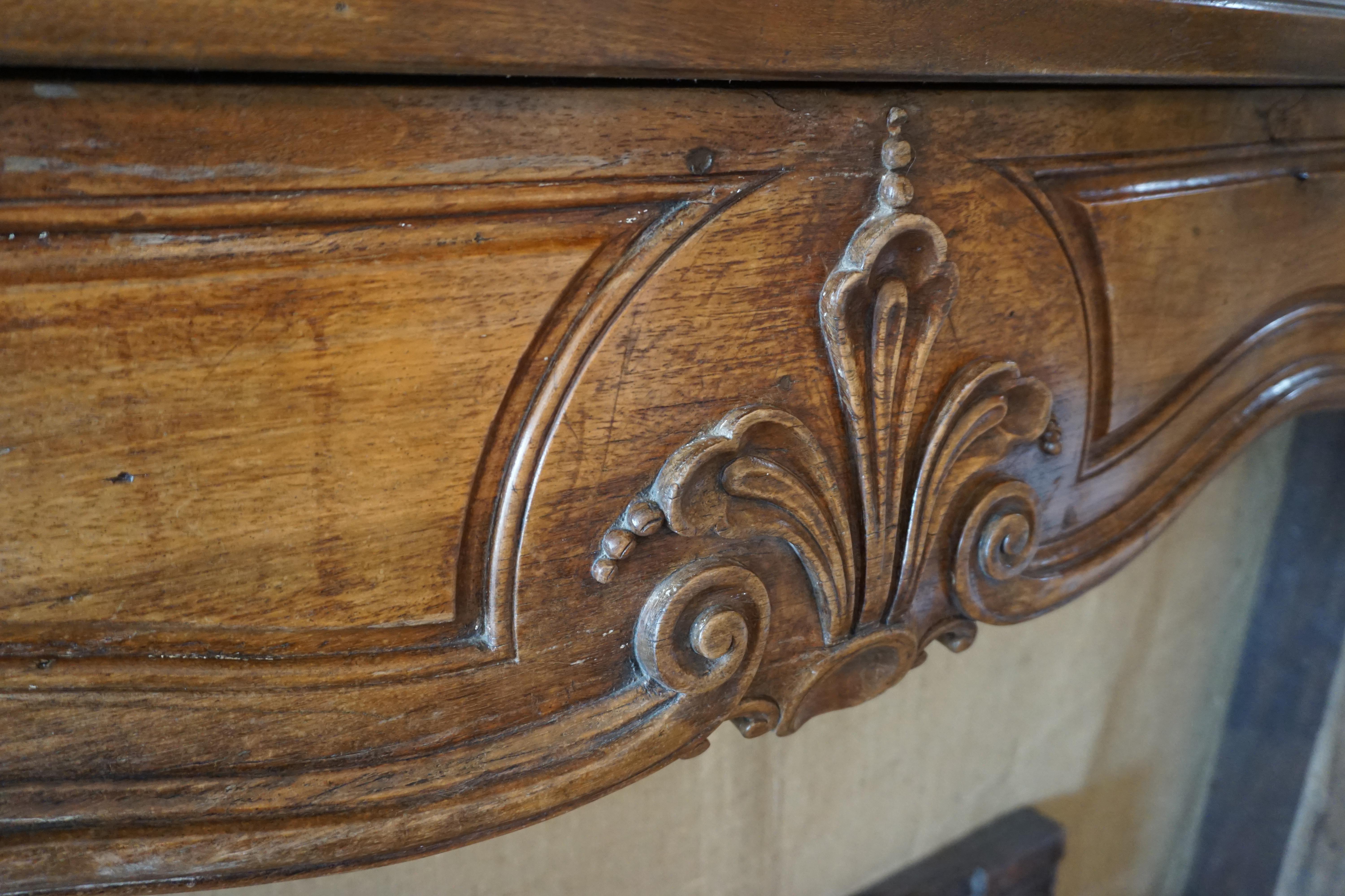 Regence walnut mantel carved with stylized fleur-de-lis. Originates from France, circa 1725.

Measurements: 84