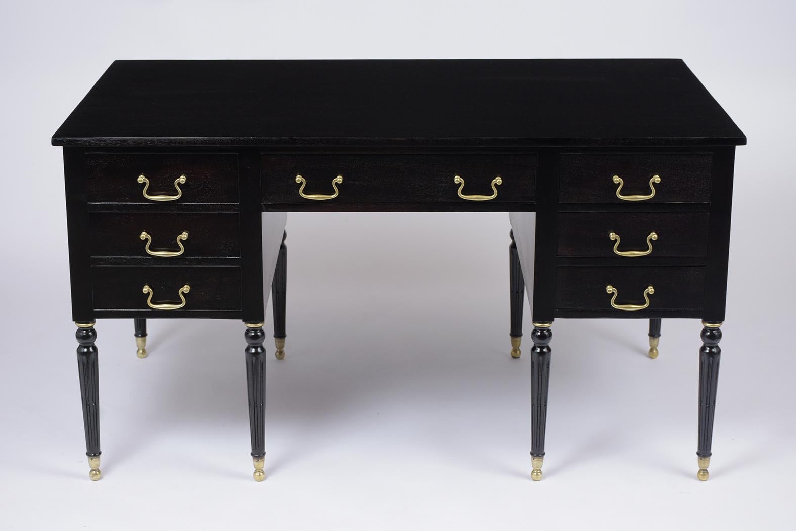 This Regency 1900s English partner desk has been restored, is made out of solid mahogany wood, and has been newly finished in an ebonized color with a lacquered finish. This executive desk features a wooden top, eight drawers total, four on each
