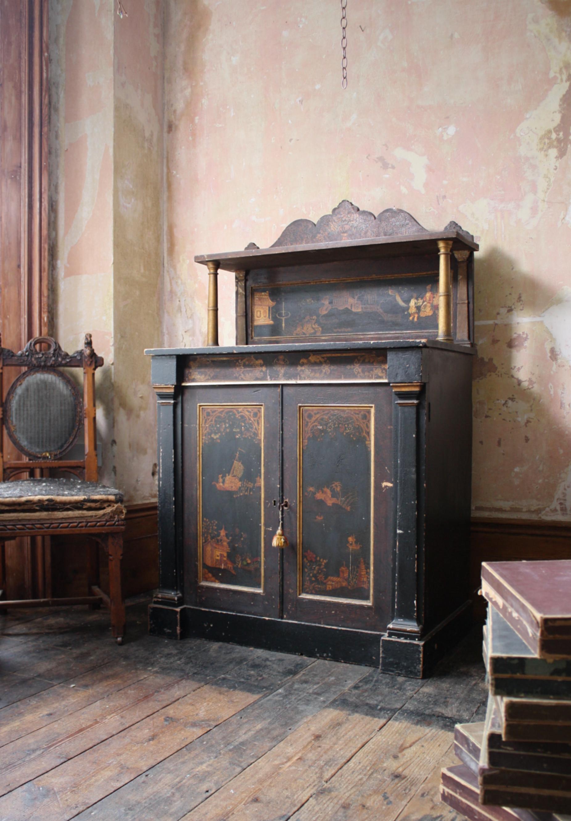 Un chiffonier/buffet de Chinoiserie de principios del siglo XIX intacto, un armario de dos puertas oculta un par de cajones extraíbles con su pintura interior crema original y un único cajón oculto encima. Columnas doradas y friso decorativo