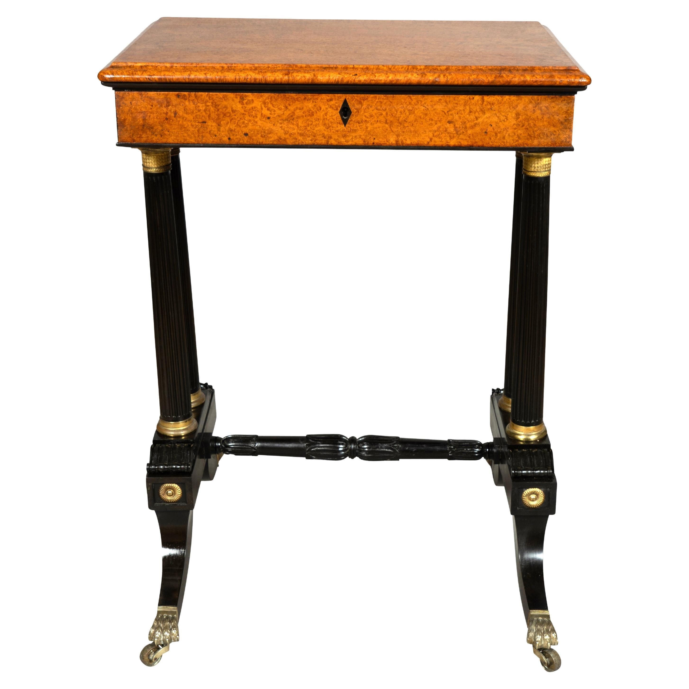 The finest quality table with rectangular hinged top opening to a fitted interior. Raised on a trestle base with two ebony columns joined by a carved ebony stretcher. Saber legs and claw casters. Bronze caps and mounts.