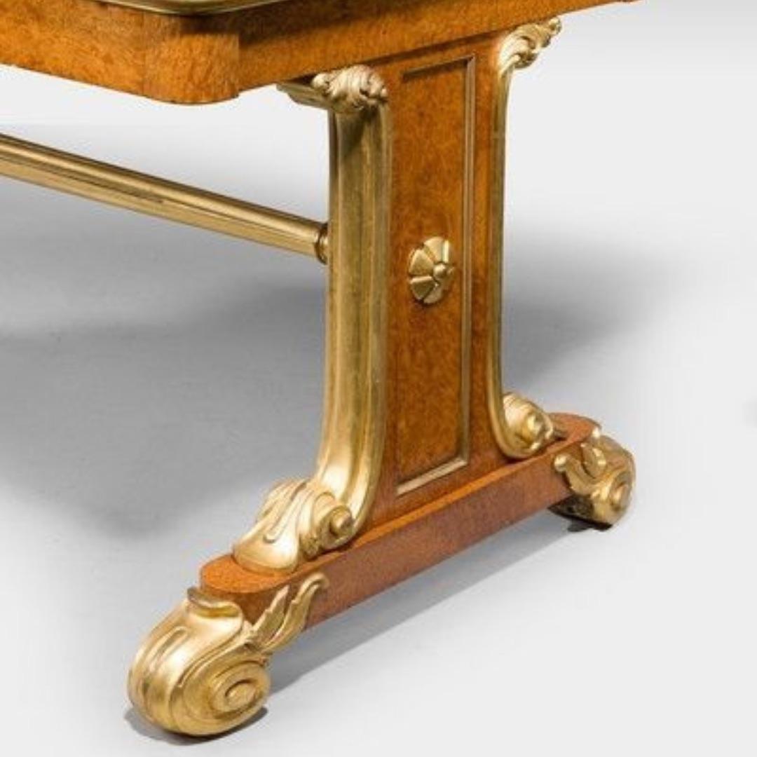 English Regency Amboyna and parcel gilt end support library table For Sale