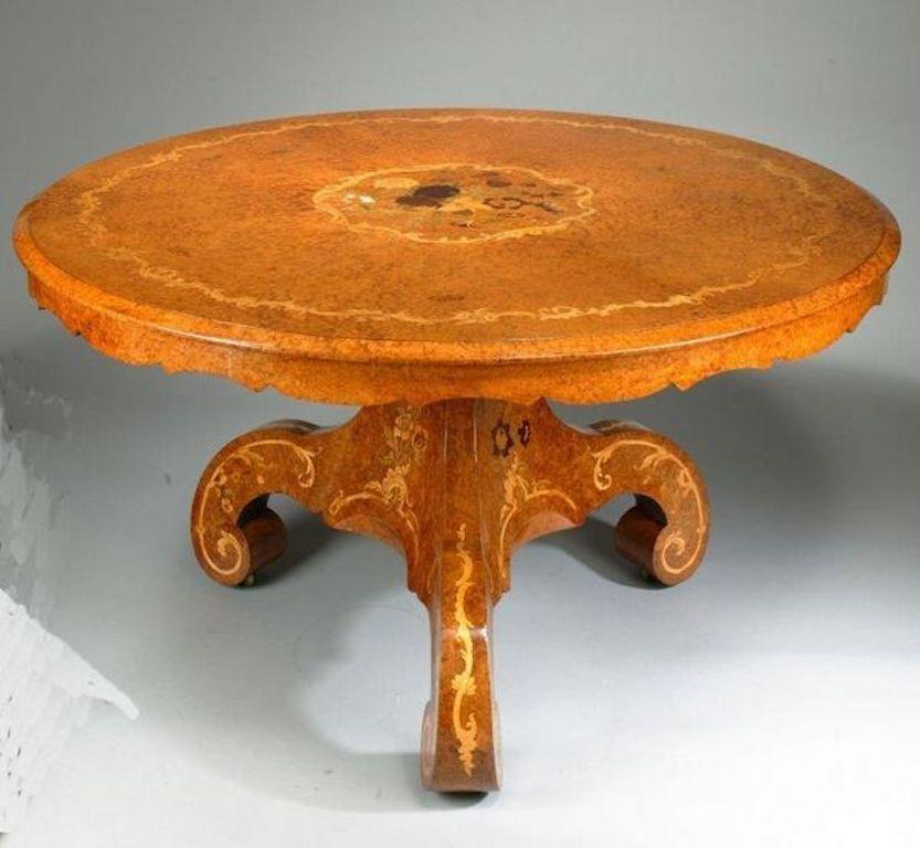 Late Regency Amboyna centre table, attributed to the workshop of Edward Holmes Baldock.
The circular top with a shaped apron set upon a solid triform base with powerful scroll feet, decorated with a central marquetry roundel of flowers and a