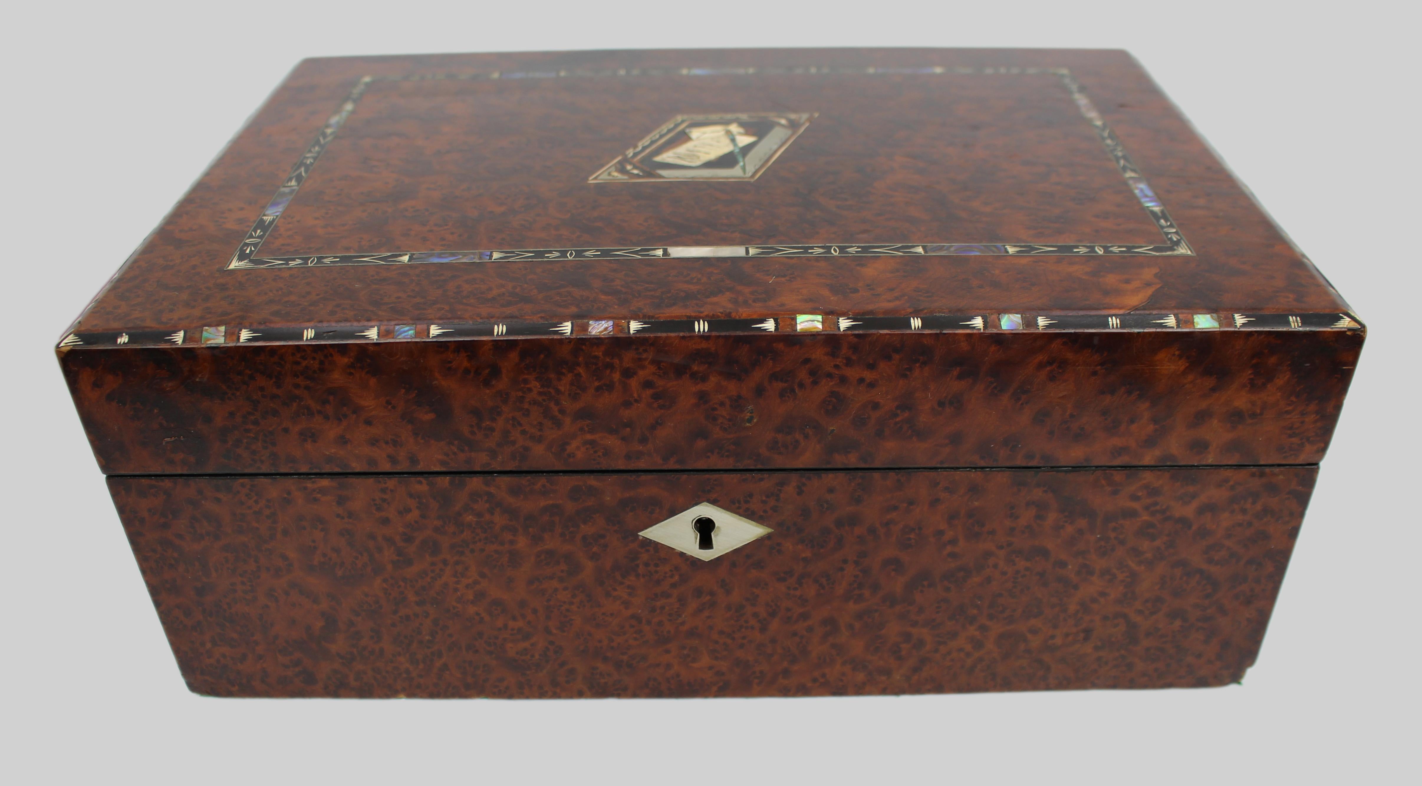 Pendiente de escritura de Amboyna de la Regencia con incrustaciones de ébano, plata y abulón
Inglaterra, hacia 1820-1835

Un talud de escritura de principios del siglo XIX, bien elaborado y chapado en amboyna ricamente labrada, cuya superficie