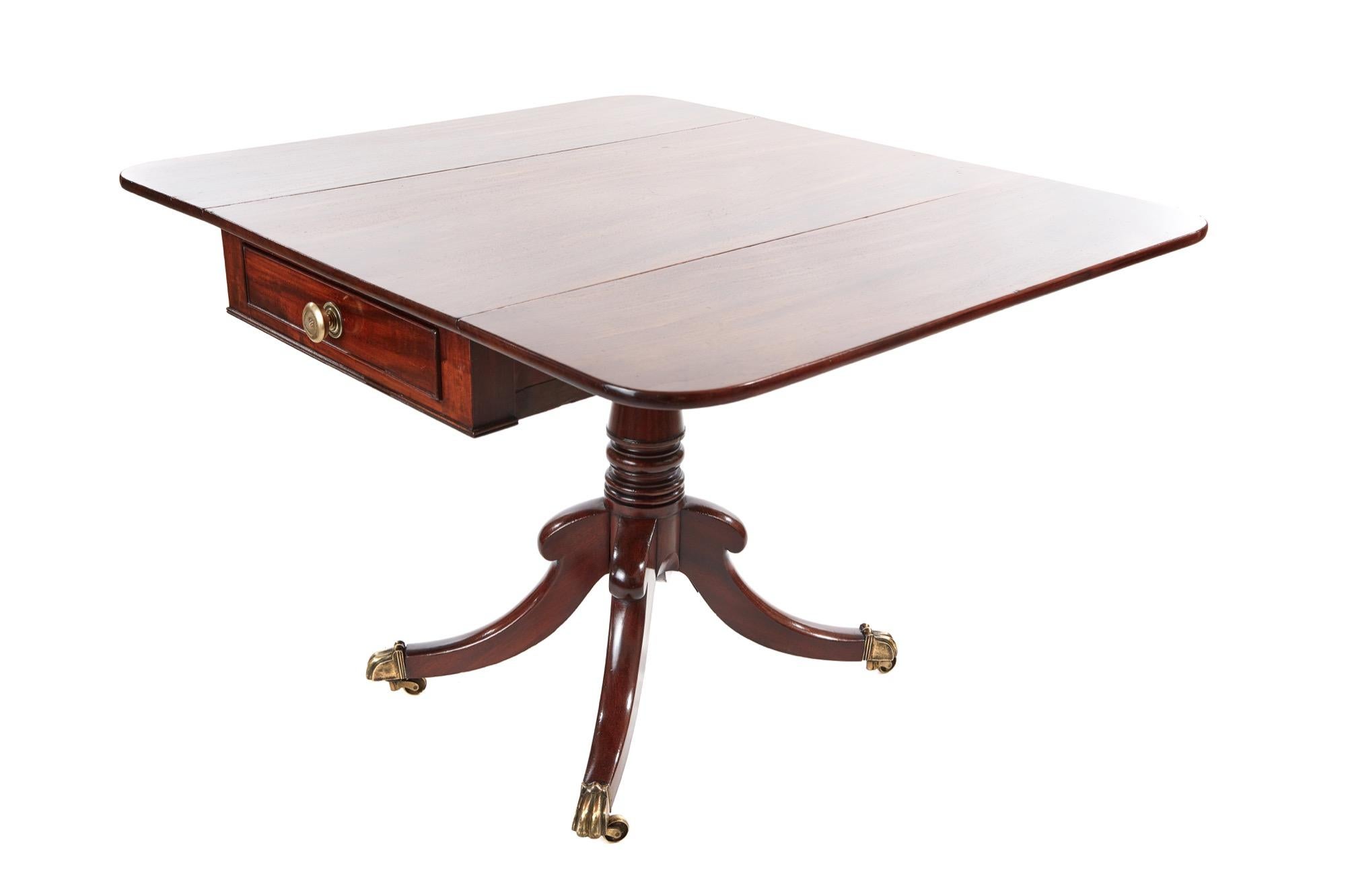 Regency antique mahogany Pembroke table with a fantastic mahogany top, two drop flaps, drawer and dummy drawer to the frieze with original brass handles. It has a lovely centre column raised on four sabred legs all terminating in original brass feet