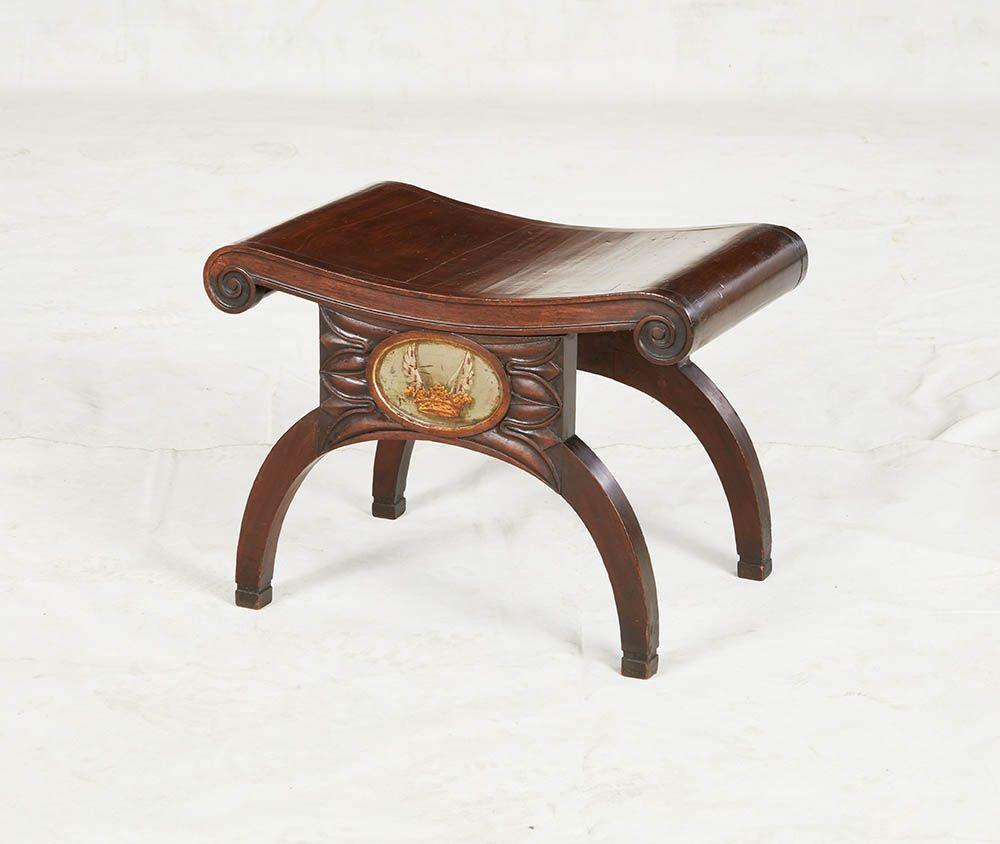 Panca in mogano del periodo della Reggenza, probabilmente di George Oakley, con seduta a listelli con volute e fregio a canali che termina con volute su un pannello intagliato con al centro lo stemma dipinto del maniero di Flete, Devon, con gambe ad
