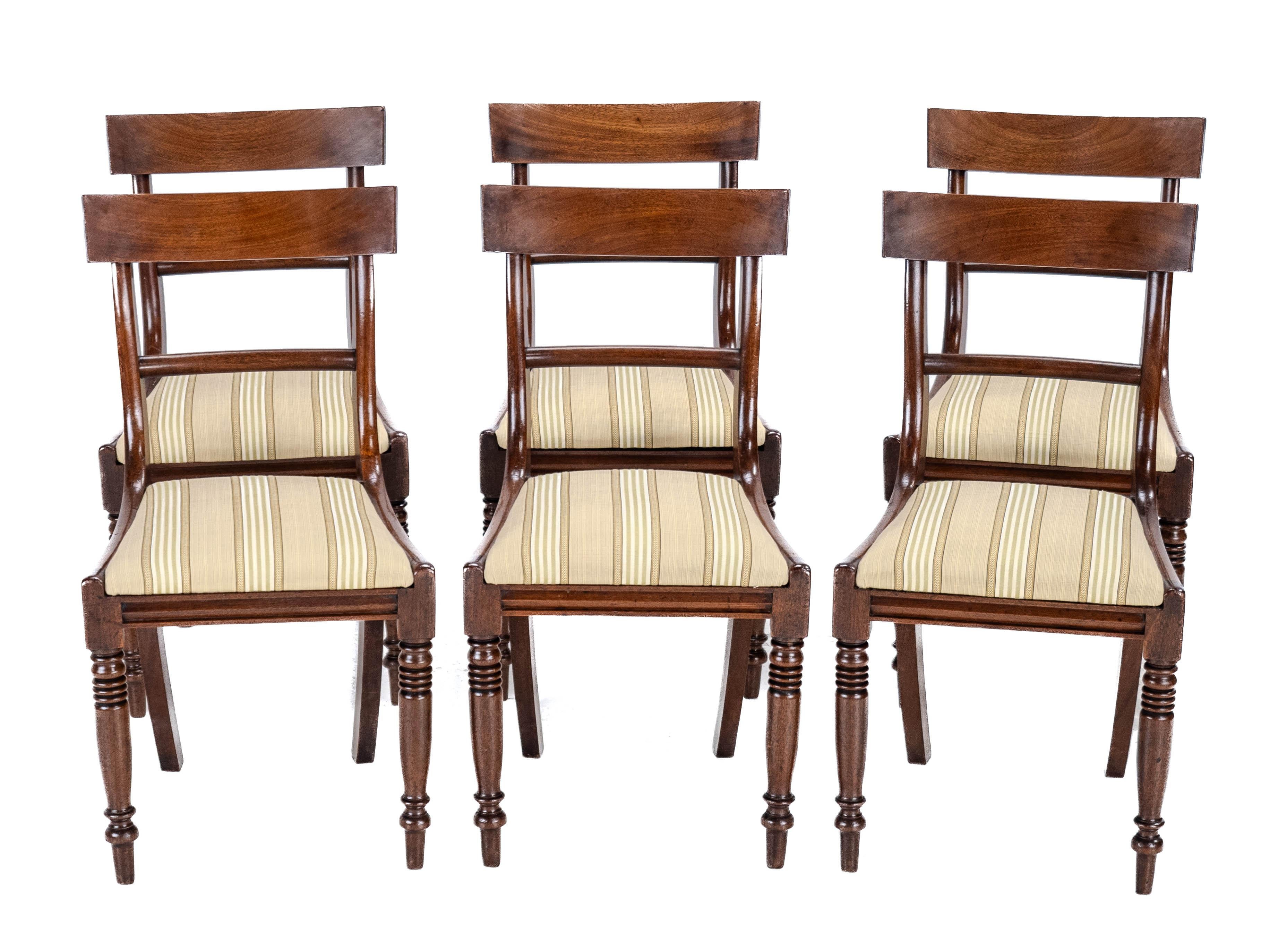 A set of 6 Regency period, mahogany dining chairs, circa 1820. This set features attractively figured timbers with curved top rails, over a single plain slat. Drop-in upholstered seats, covered in a quality woven Regency stripe fabric in green,