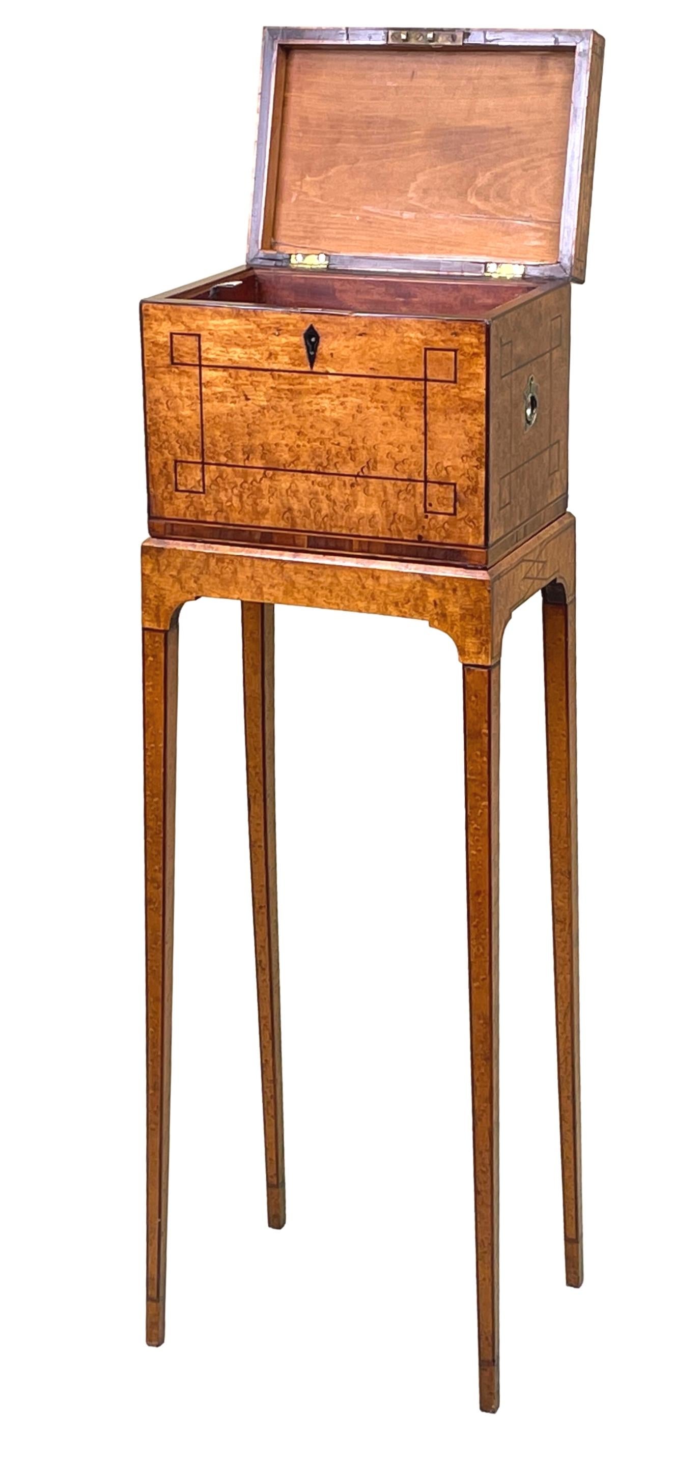 A fine early 19th century Georgian early Regency Period birdseye maple veneered jewellery, or sewing, box having hinged lid enclosing three removable mahogany lined trays with original flush fitted brass handle to each side, housed on original stand