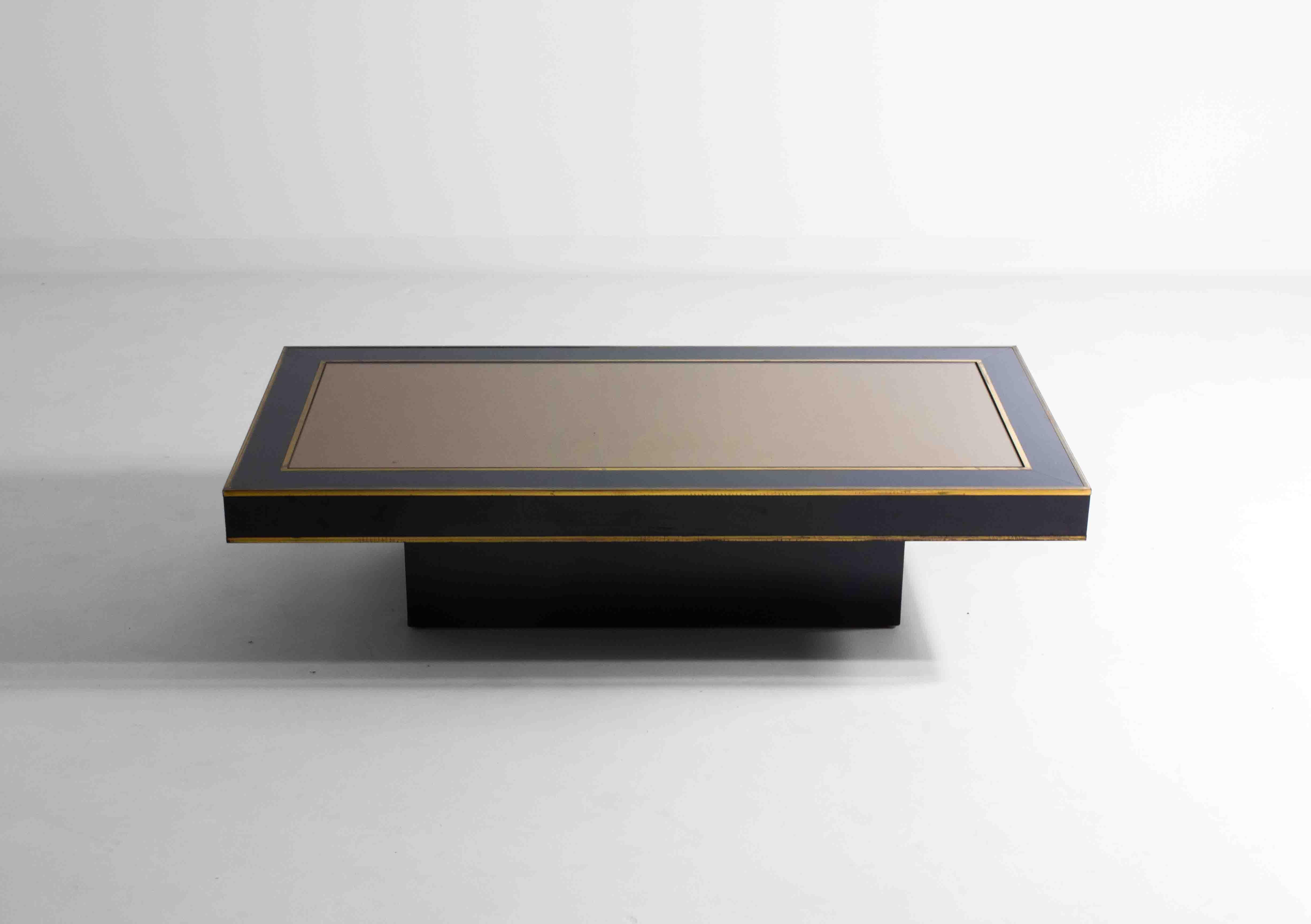 Cette table basse italienne aux lignes épurées, fabriquée en bois stratifié noir et dotée d'un plateau en miroir, s'intégrerait parfaitement dans un intérieur de style Miami Vice des années 1980. Les détails en laiton permettent à cette table basse