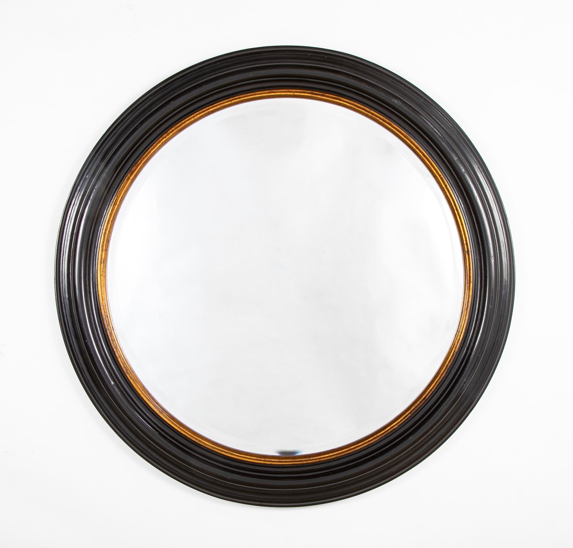 Handsome large scale round English Regency style mirror with lovely shape and gilt inner molding. The mirror glass is beveled. This timeless classic style is a great match for any interior, wonderful over a mantel, or entry way console table, or
