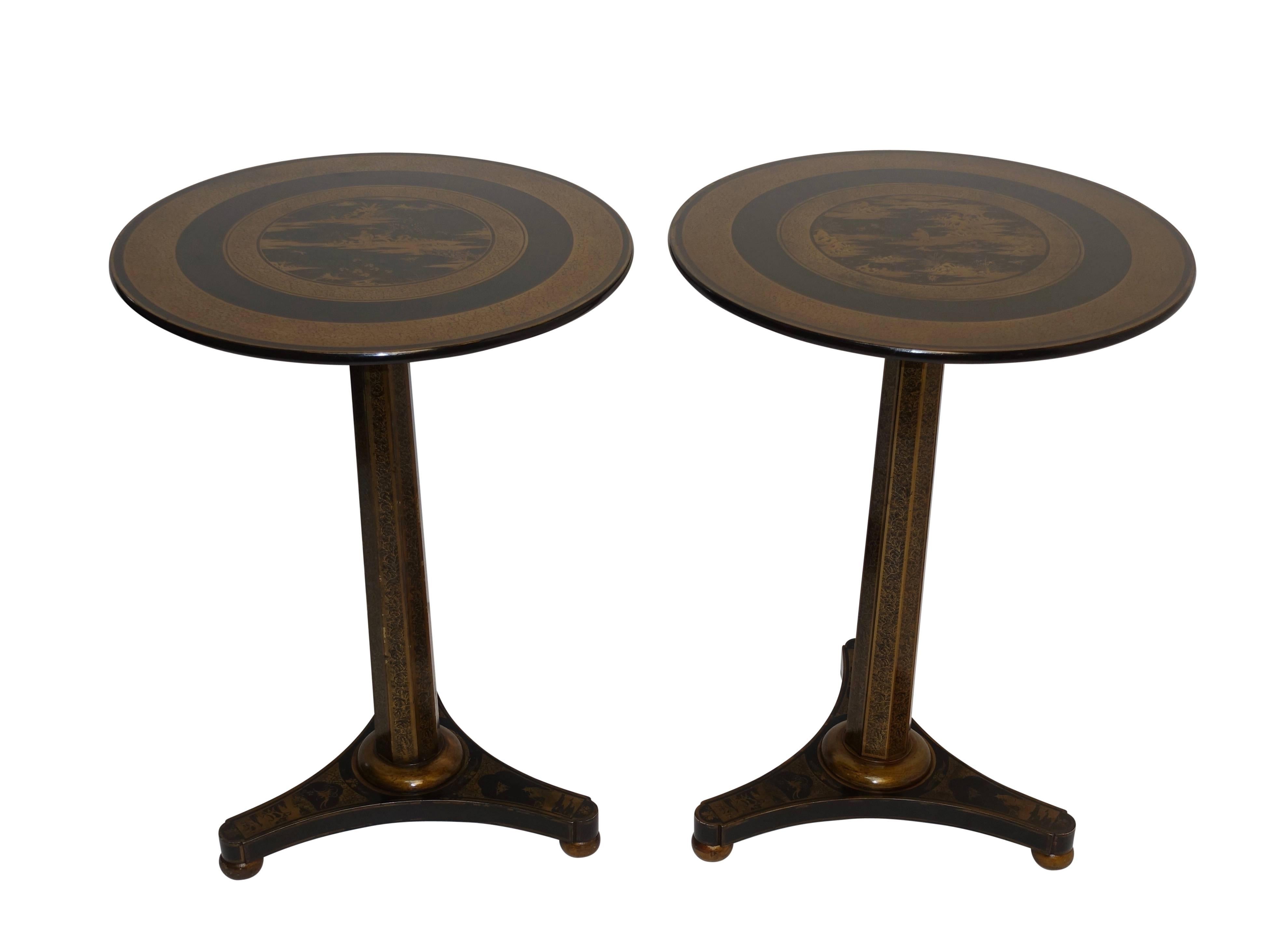 A pair of Regency style black lacquered side tables with gold painted chinoiserie scenes and having bands of vining leaves running along the tapering octagonal column, England, mid-19th century.