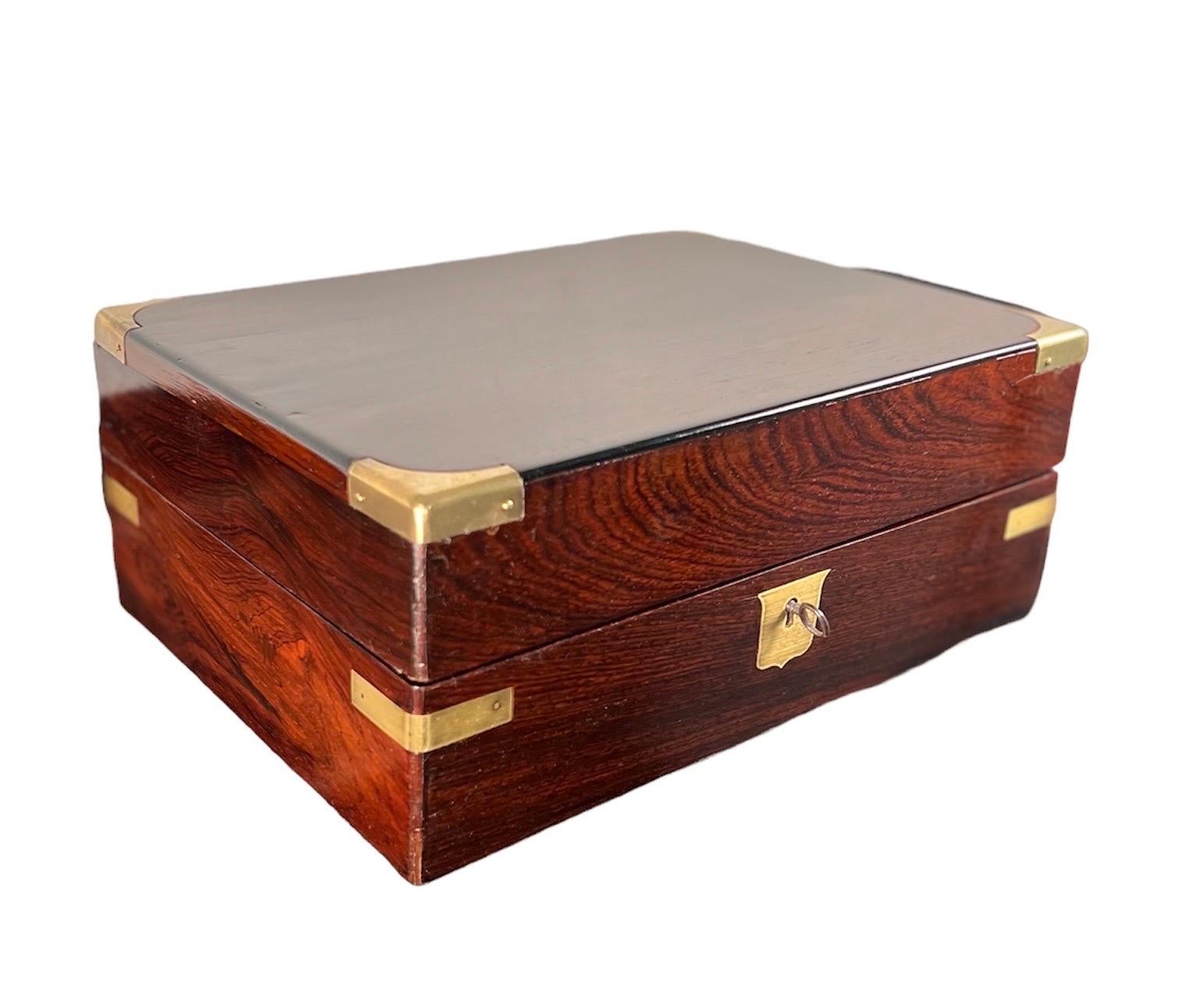 Regency Brass Bound Rosewood Fitted traveling , dressing box 
With fitted interior,  containing 2 fragrance bottles. Silver lidded makeup 
Jars, a mirror & a tooled leather compartment cover. Also with one key.