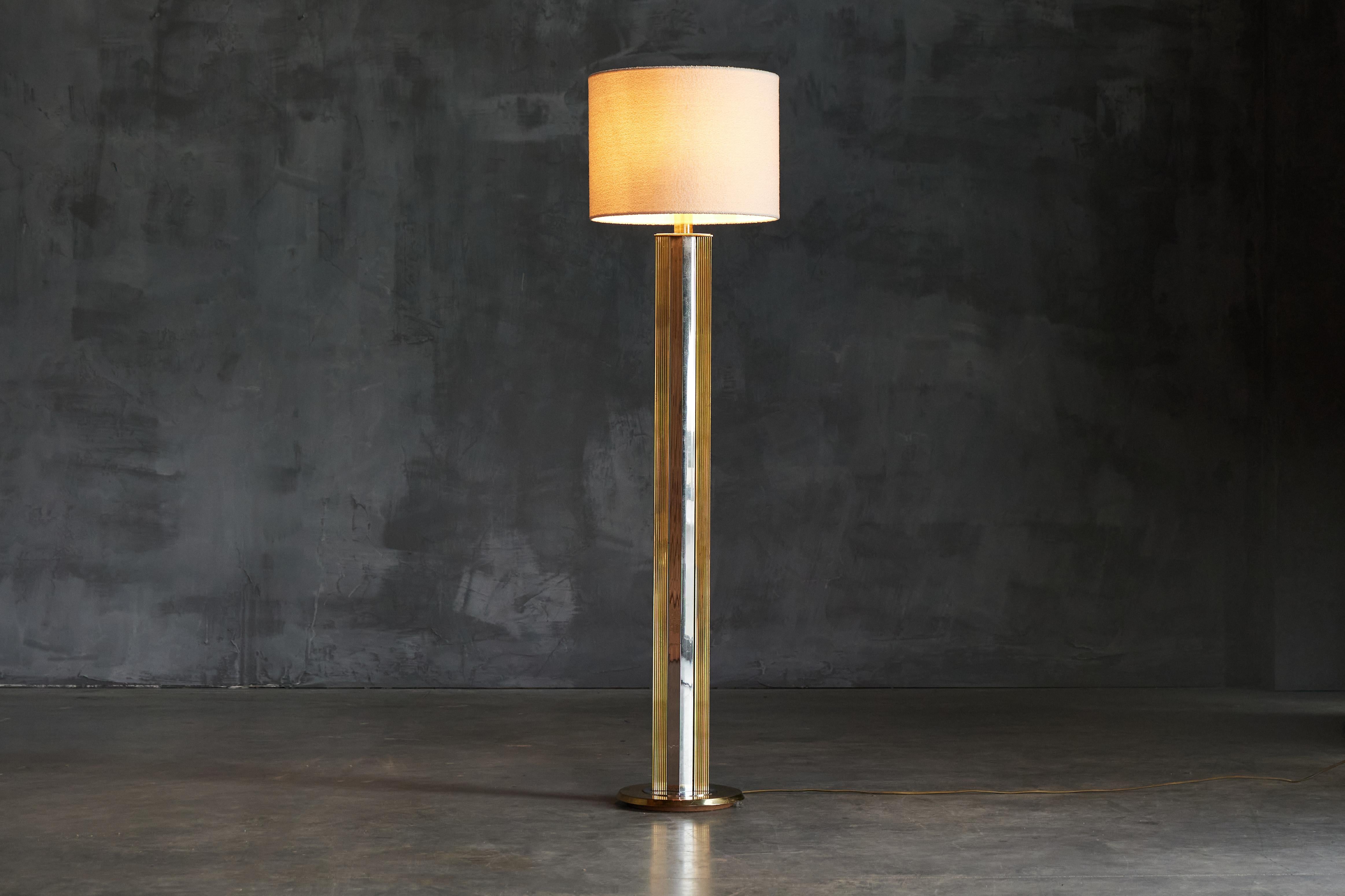 Step back in time to the opulent era of the 1970s with our brass regency floor lamp. Its base features a blend of silver and gold finishes, exuding an air of vintage charm and sophistication. The round shade of luxurious white bouclé emits a soft,