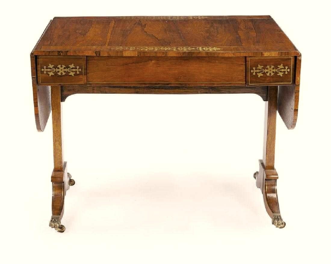 Exquisite 19th century English Regency brass inlaid rosewood drop-leaf library table.
The beautiful rosewood top inlaid with the most intricate brass border over a brass inlaid frieze with a single drawer above two supports terminating in bronze