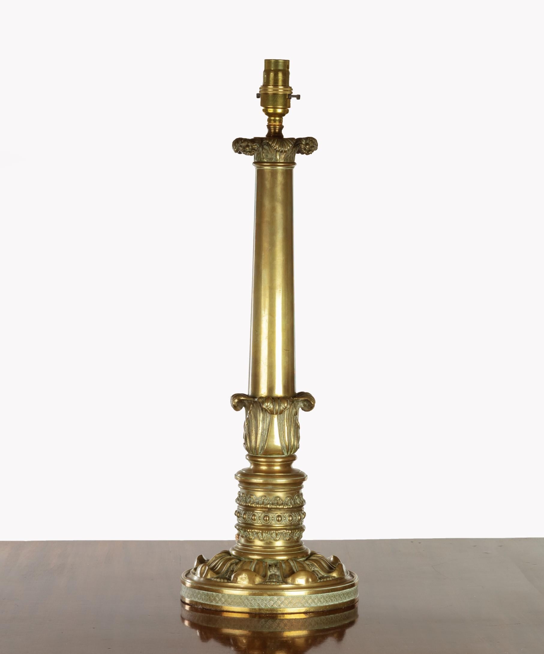 A fine Regency period brass table lamp, the lamp holder above an acanthus capital and further acanthus decoration to the stem, the base decorated with scrolling lotus leaves. Professionally electrified and tested for UK current. The lamp has a