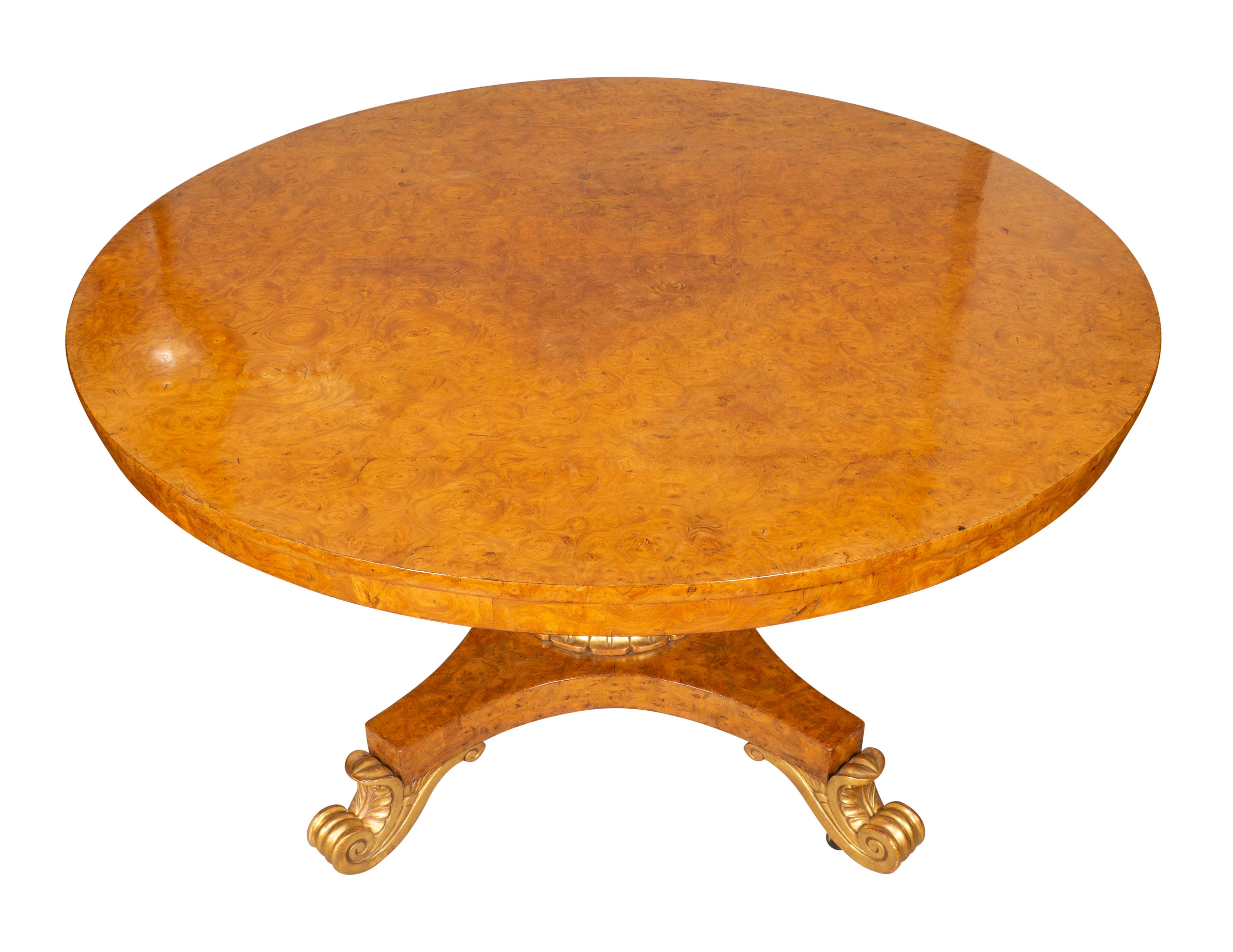 With a circular hinged top with wonderful caramel color burl and conforming apron raised on an acanthus carved baluster support joining a quadripartite base with gilded details and ending on scroll gilded feet. Can also be used as a small dining