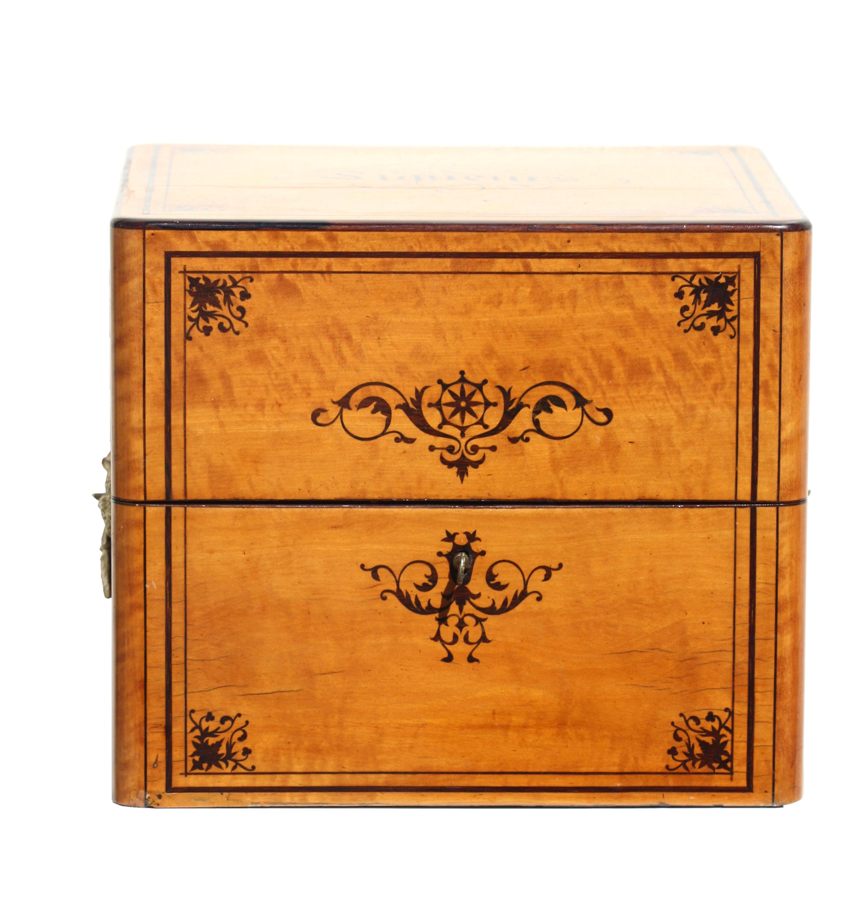 Regency burl wood and inlaid liquor Tantalus 
case in a light burl wood with ebonized inlaid panels, the top with inlaid script 