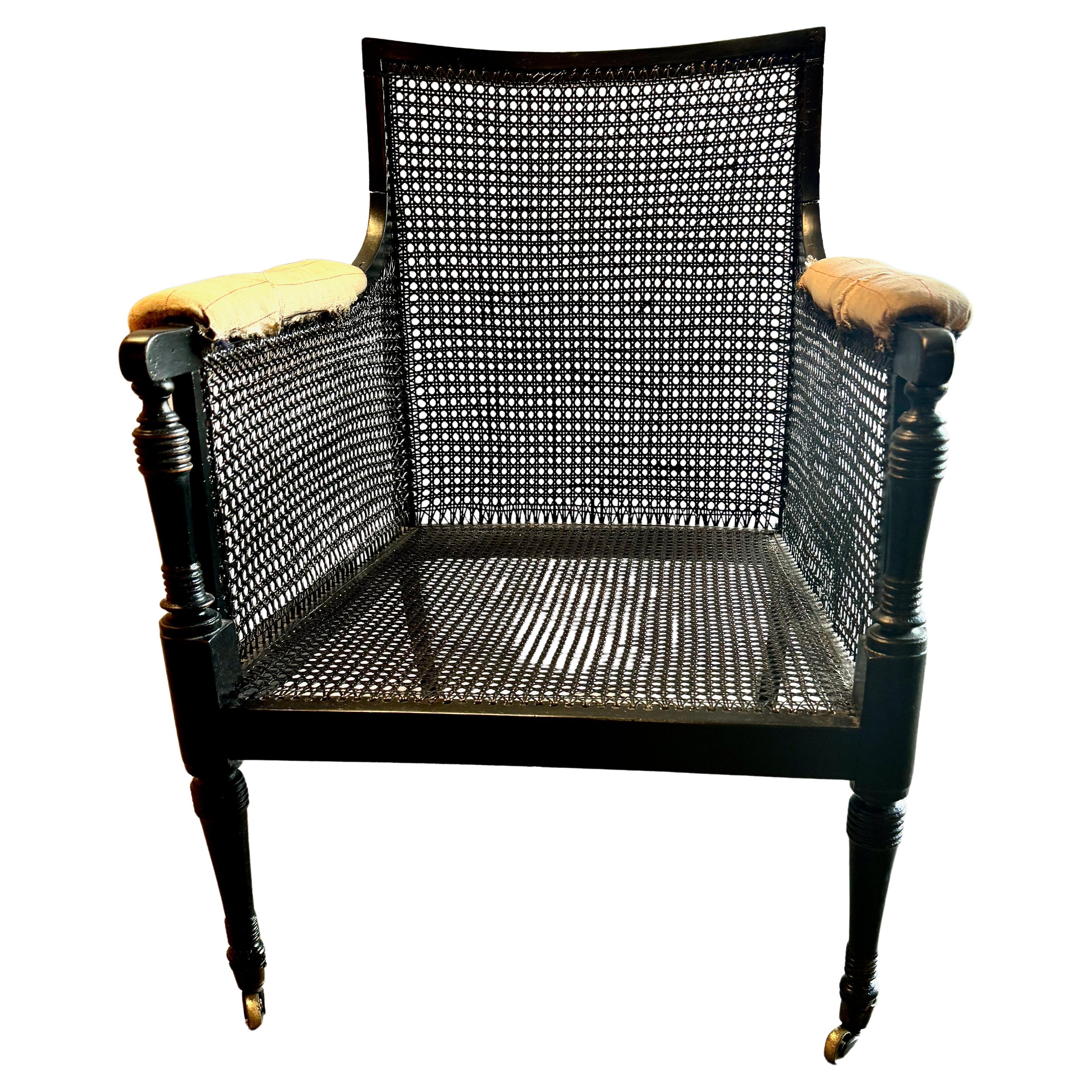 Il s'agit d'un exemple classique de bibliothèque Bergère cannelée de la Régence. Cette chaise date du début du XIXe siècle et conserve tous ses éléments d'origine. Nous avons nettoyé et poli la surface ébonisée d'origine, avec des retouches mineures