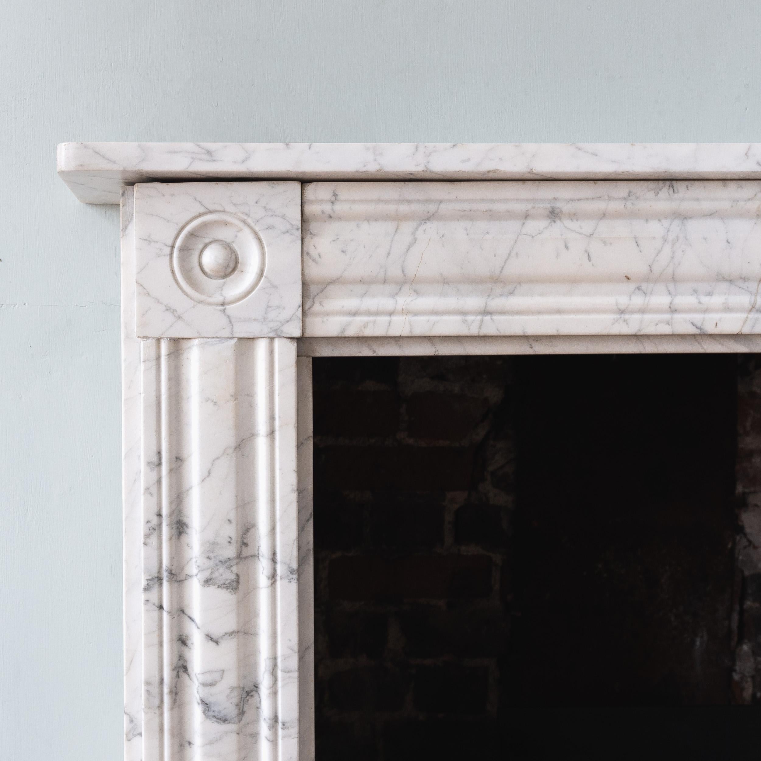 An English Regency period Carrara mrable bullseye fireplace circa 1820, with moulded frieze and jambs.

Opening width 93.5 cm x 90 cm high, Outside jamb to jamb 127.5 cm wide.

Ready for installation and use.