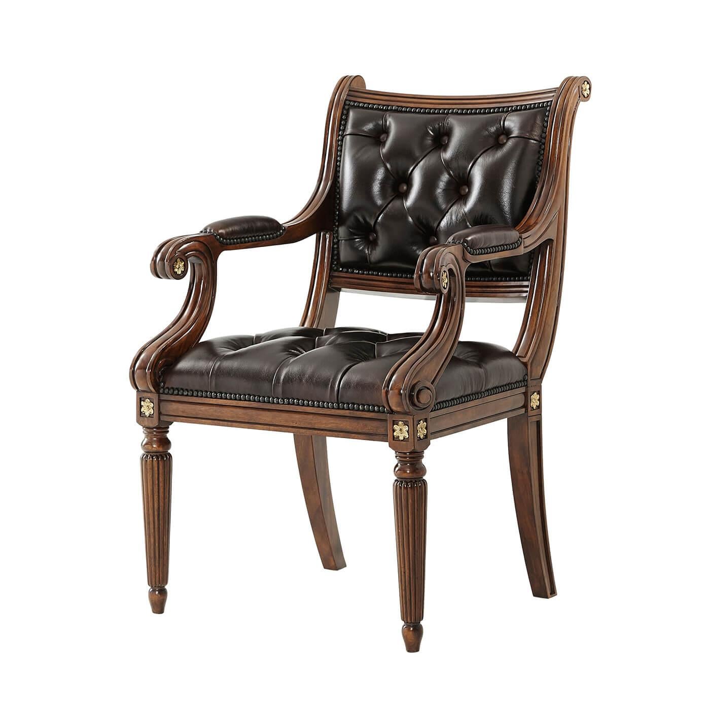 An English Regency style hand-carved library armchair, with an upholstered and tufted panel back and seat, with brass nailhead trim, scroll arms, on turned, tapered, and reeded legs. With a brown Old English leather upholstery. 

Dimensions: 24