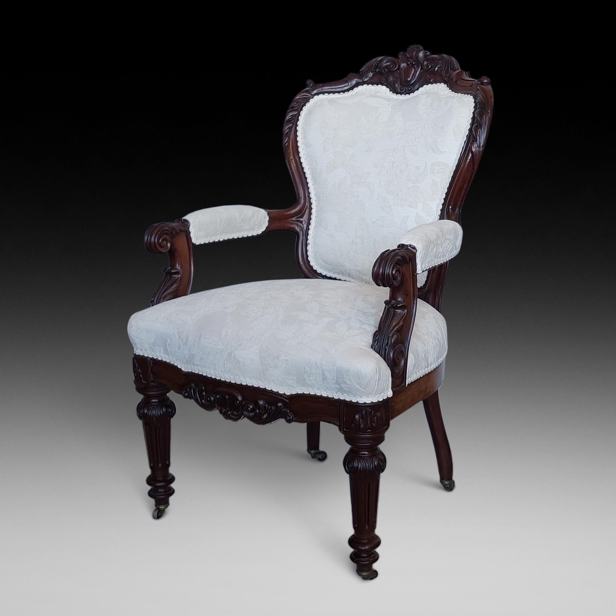 Poltrona Regency in mogano intagliato con decorazioni a foglie d'acanto, volute e fogliame, gambe tornite in canna su rotelle in lignum vitae c1820 - 26 